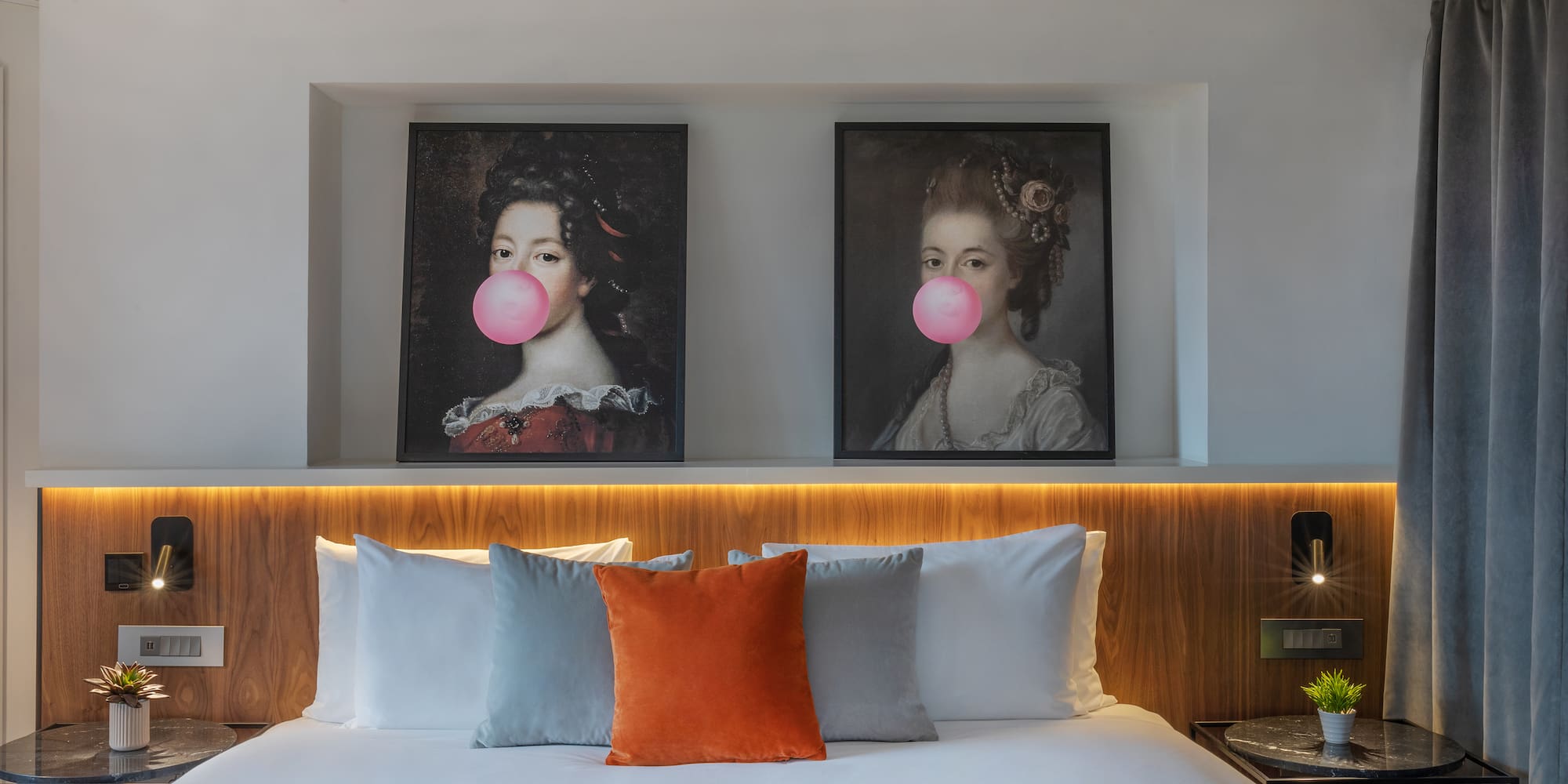 a bed with a couple of pictures of women blowing bubbles
