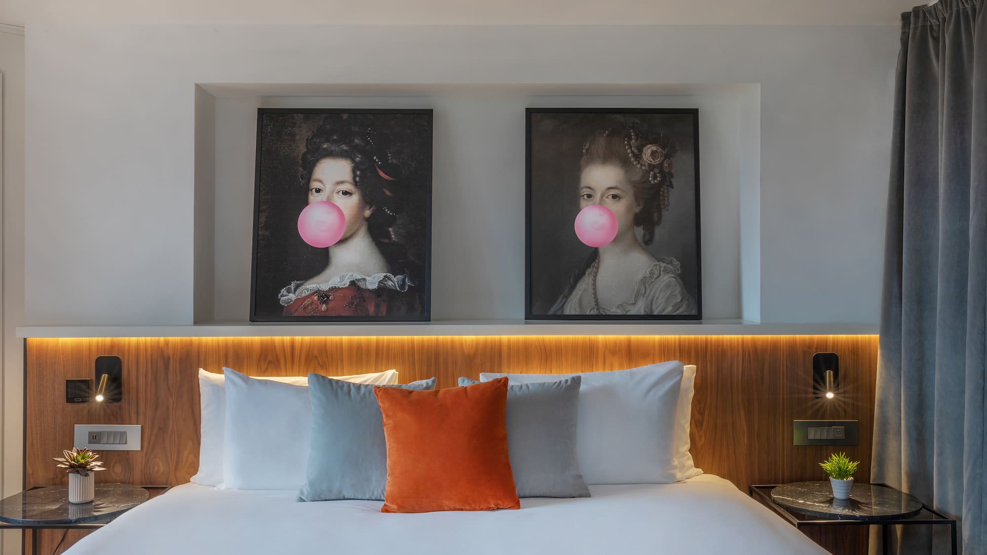 a bed with a couple of pictures of women blowing bubbles