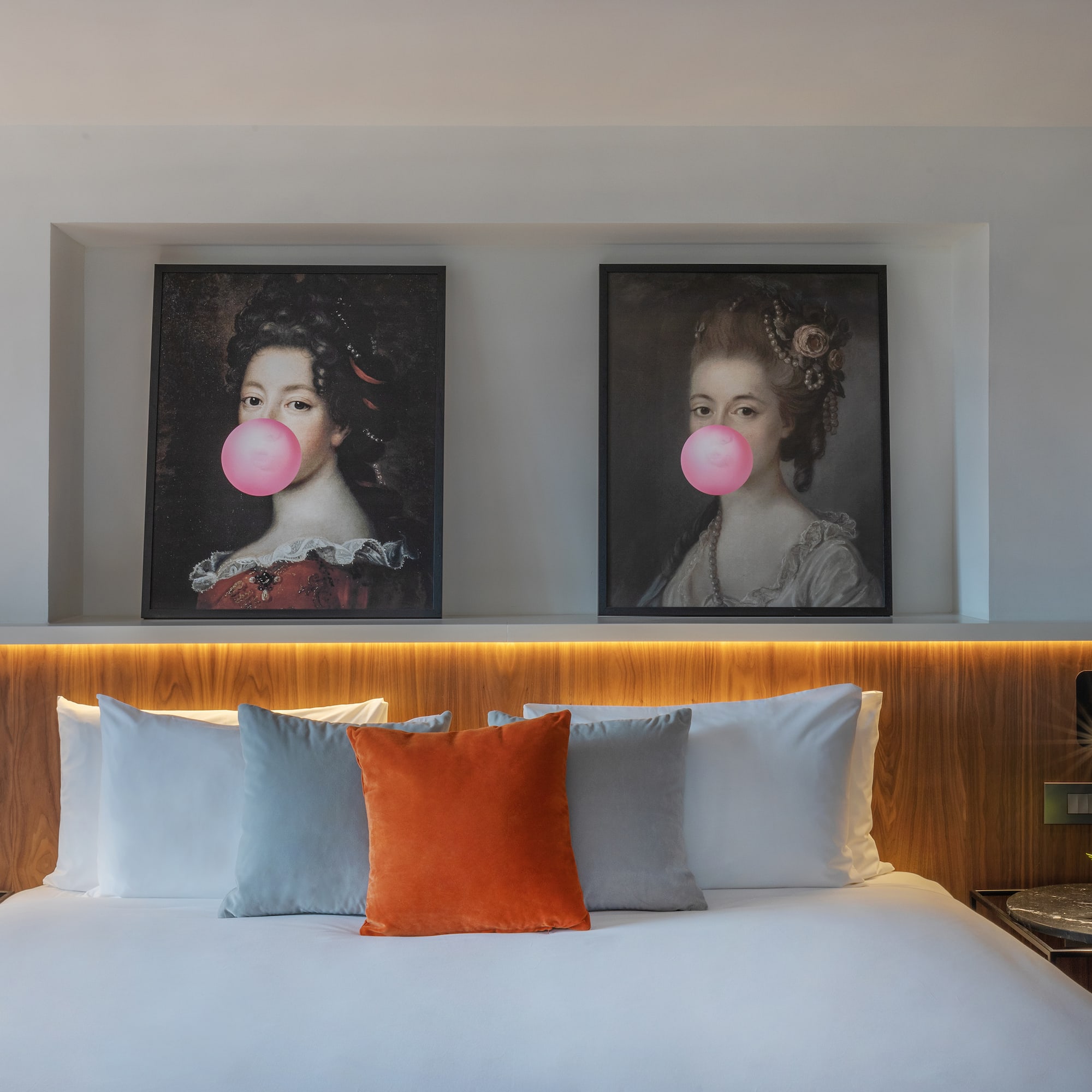 a bed with a couple of pictures of women blowing bubbles