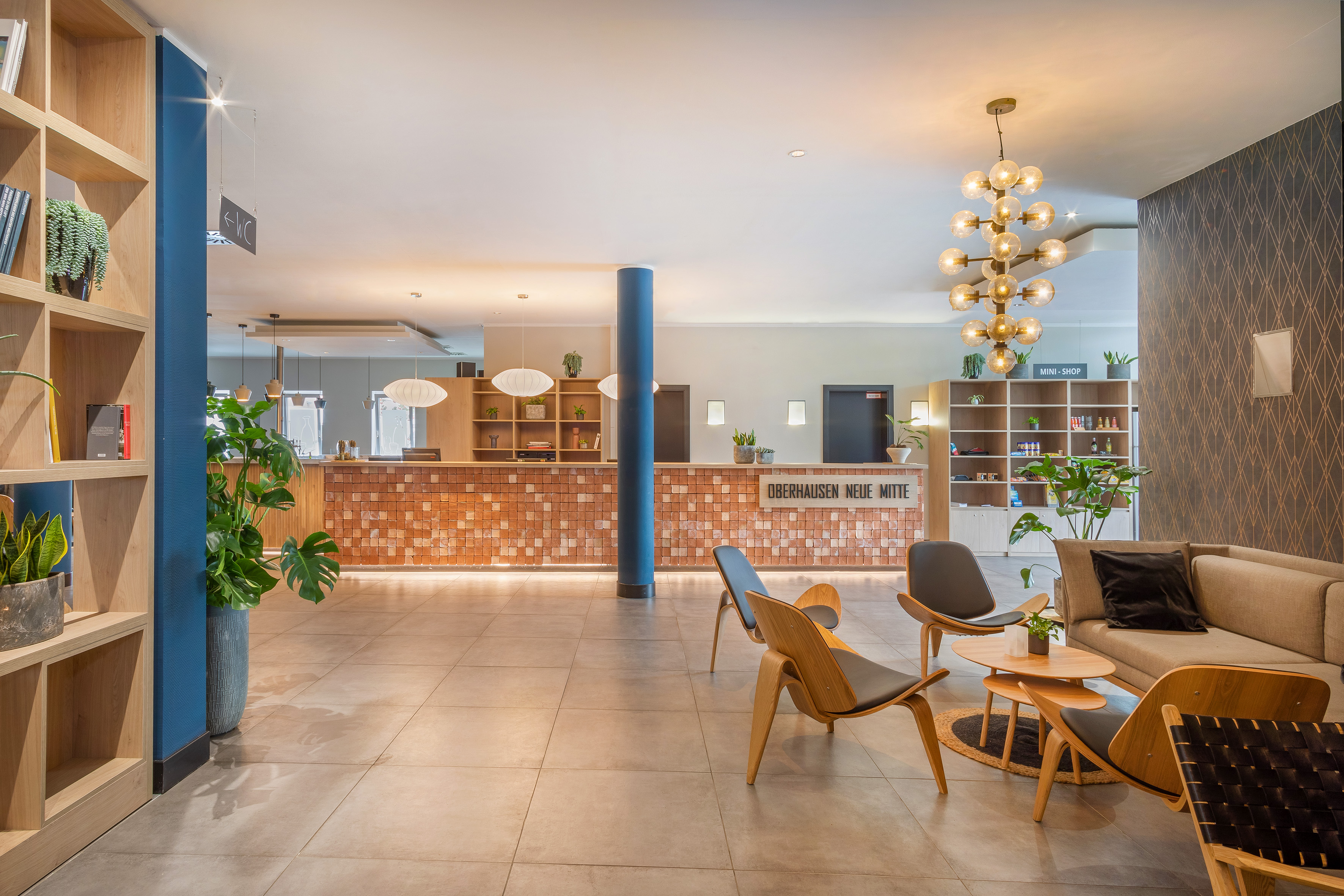 a lobby with a large plant and a couch