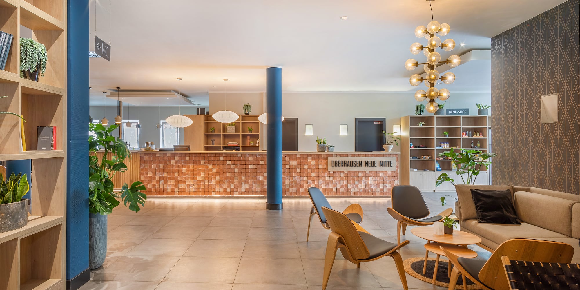 a lobby with a large plant and a couch