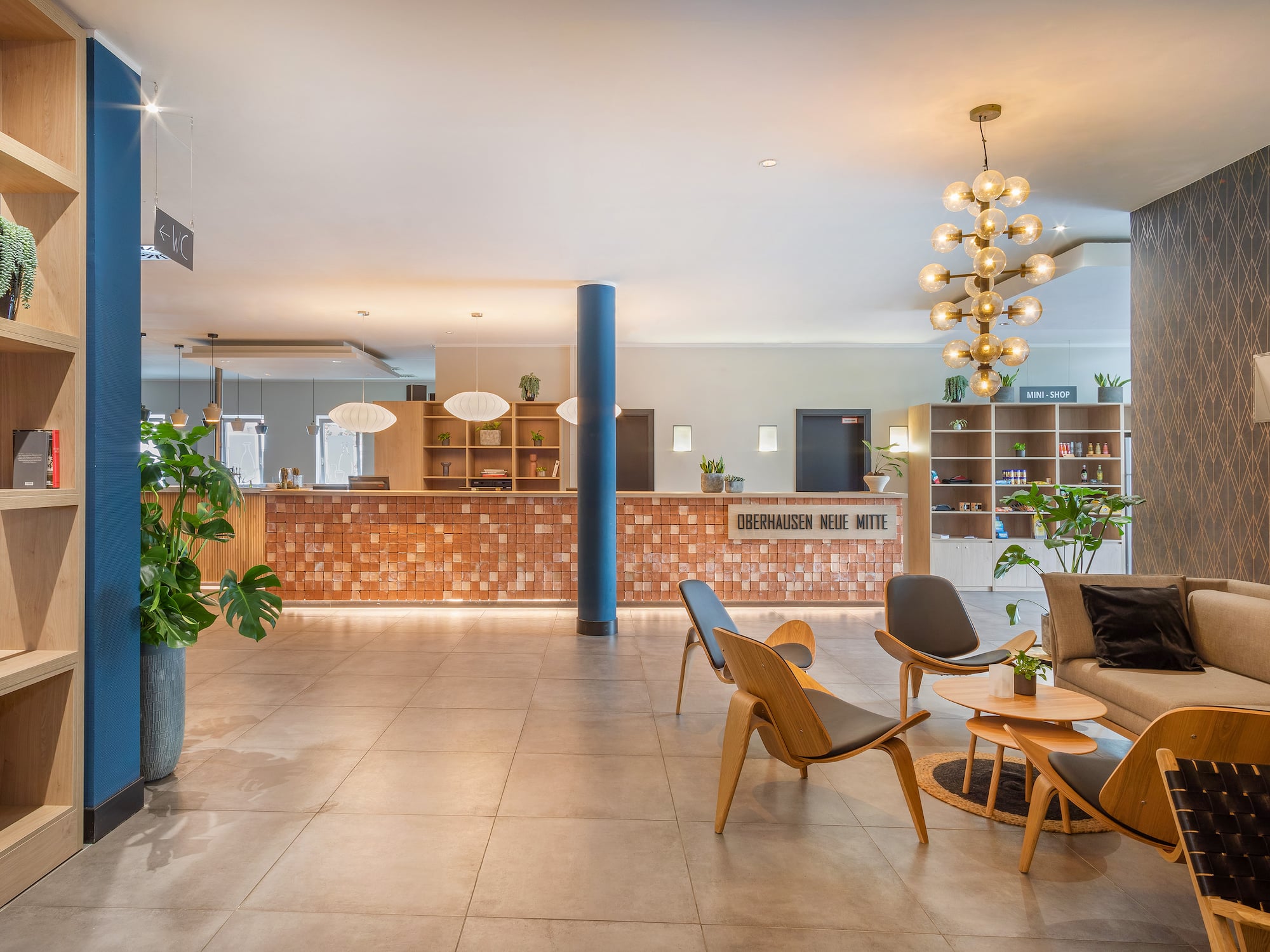 a lobby with a large plant and a couch