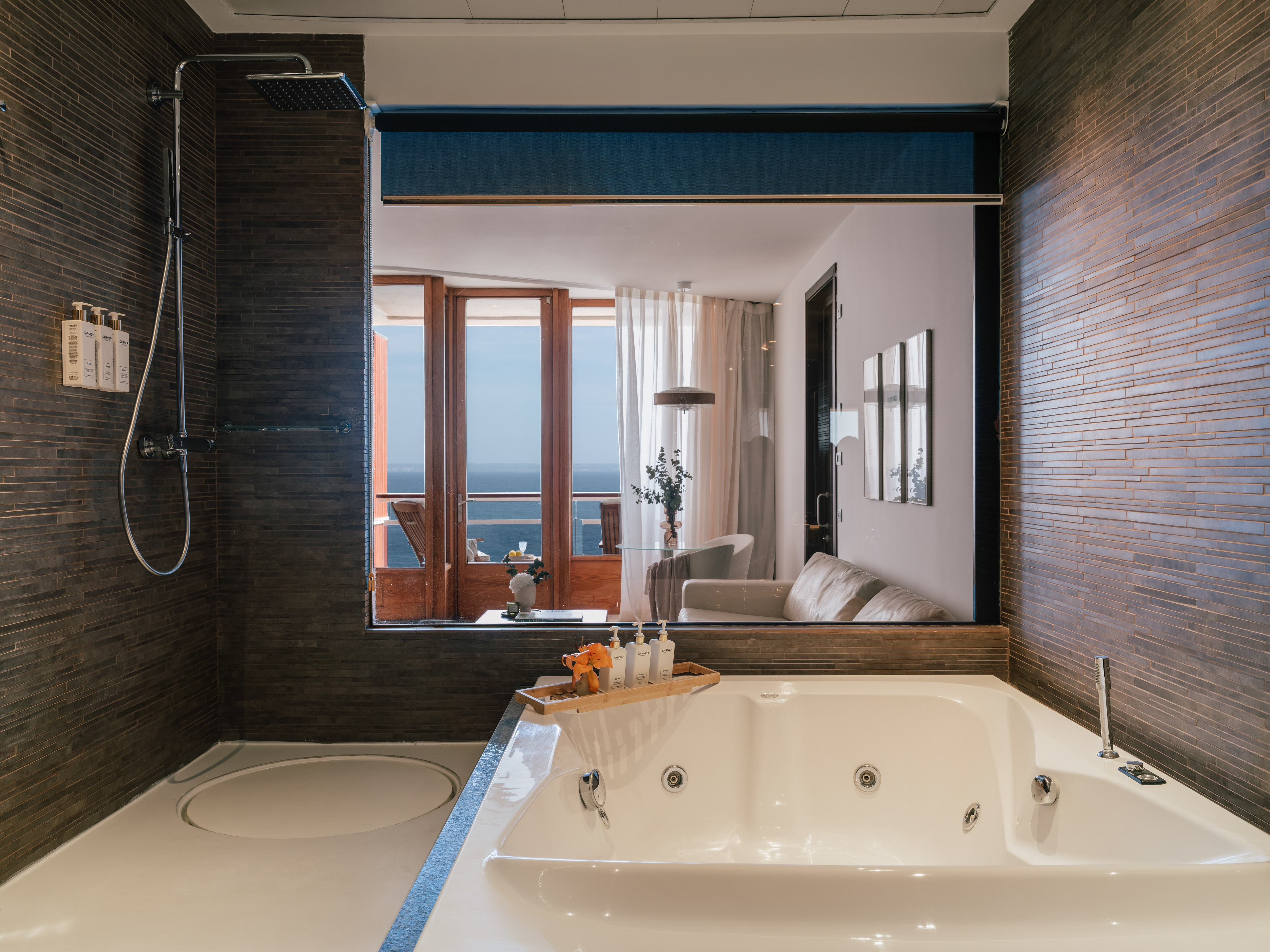 Modern luxury bathroom with jacuzzi bathtub, shower, and ocean view.