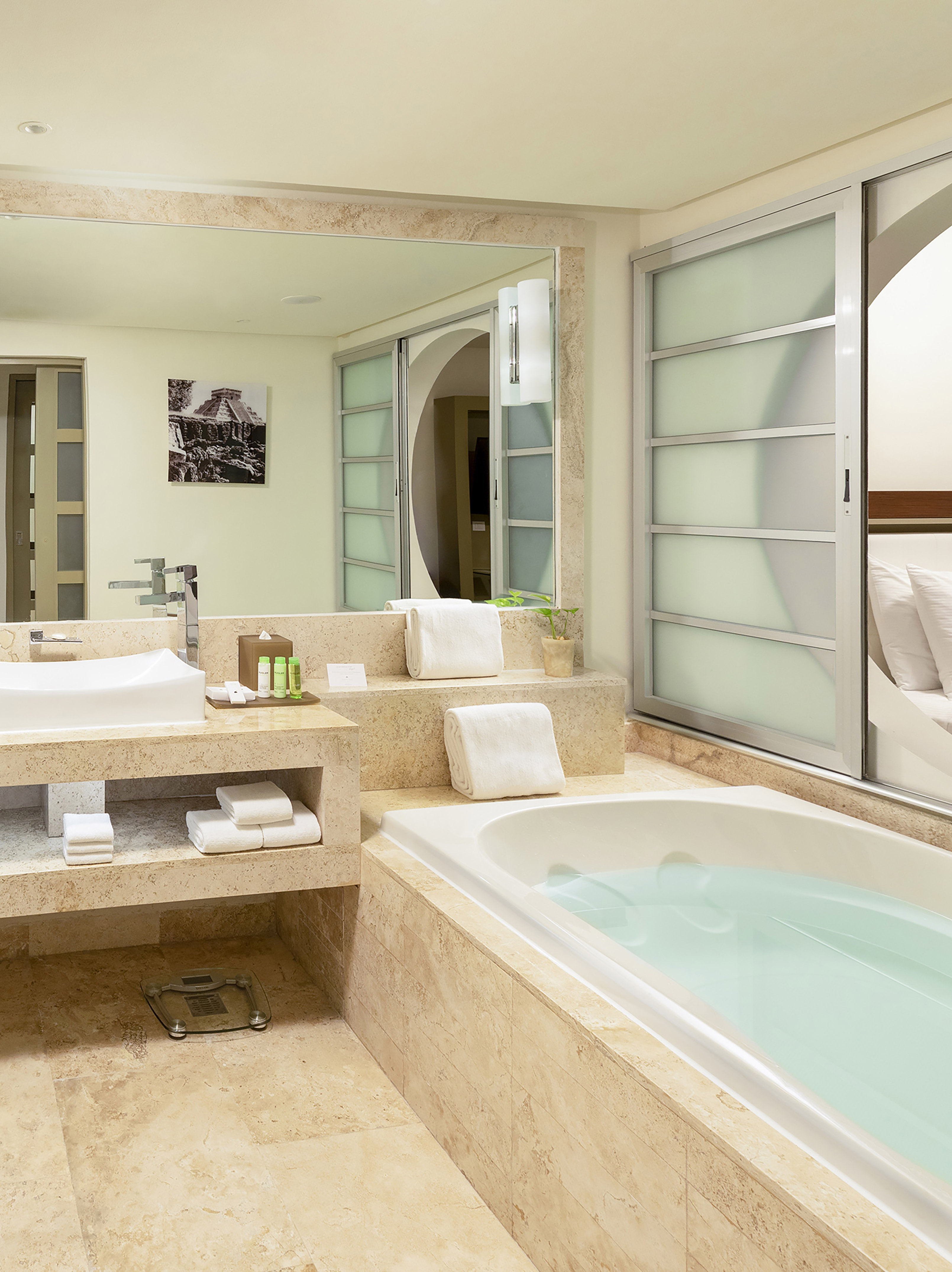 Contemporary bathroom with soaking tub, marble vanity, and sliding glass doors.