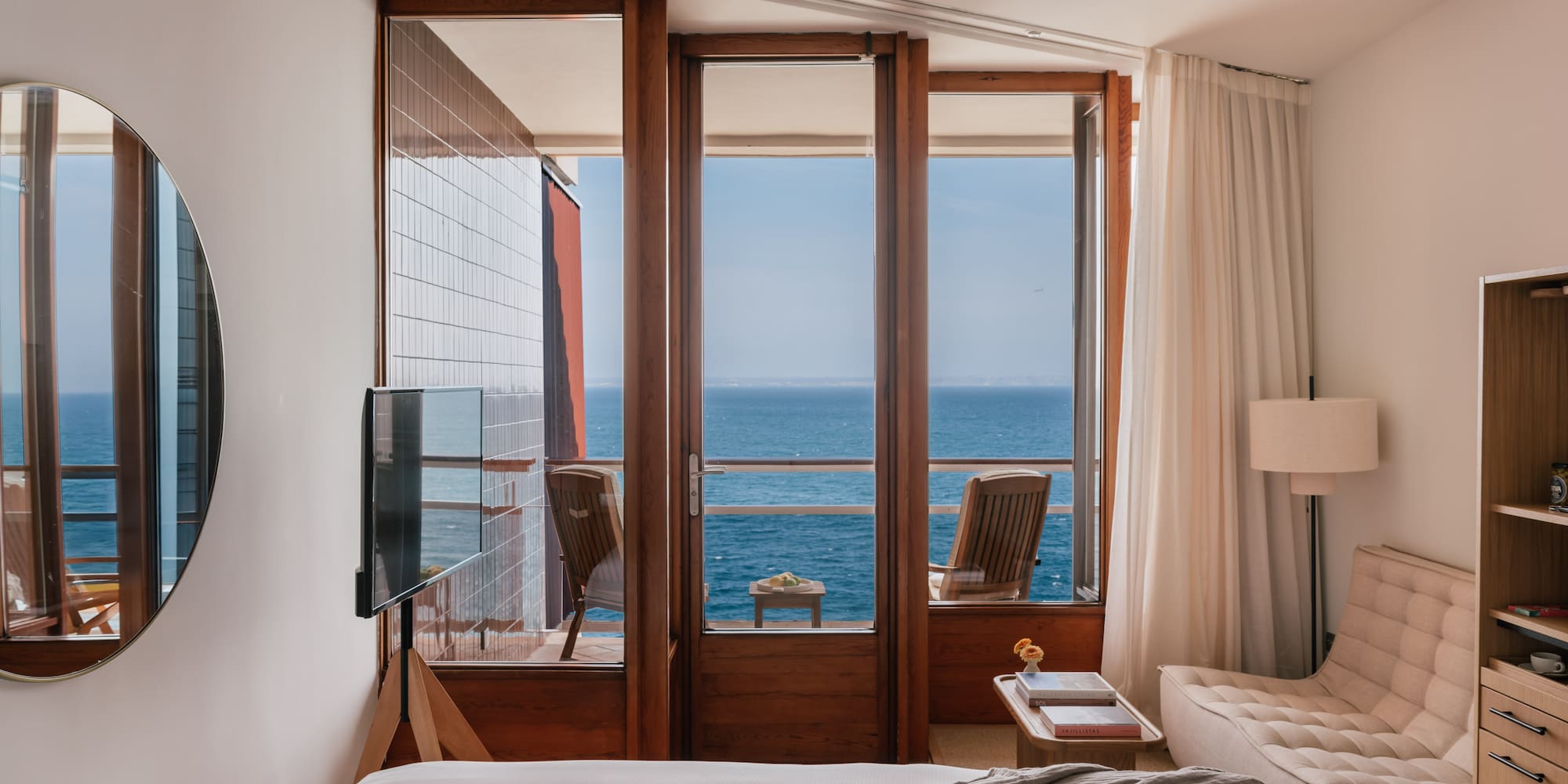 a bedroom with a view of the ocean from the balcony
