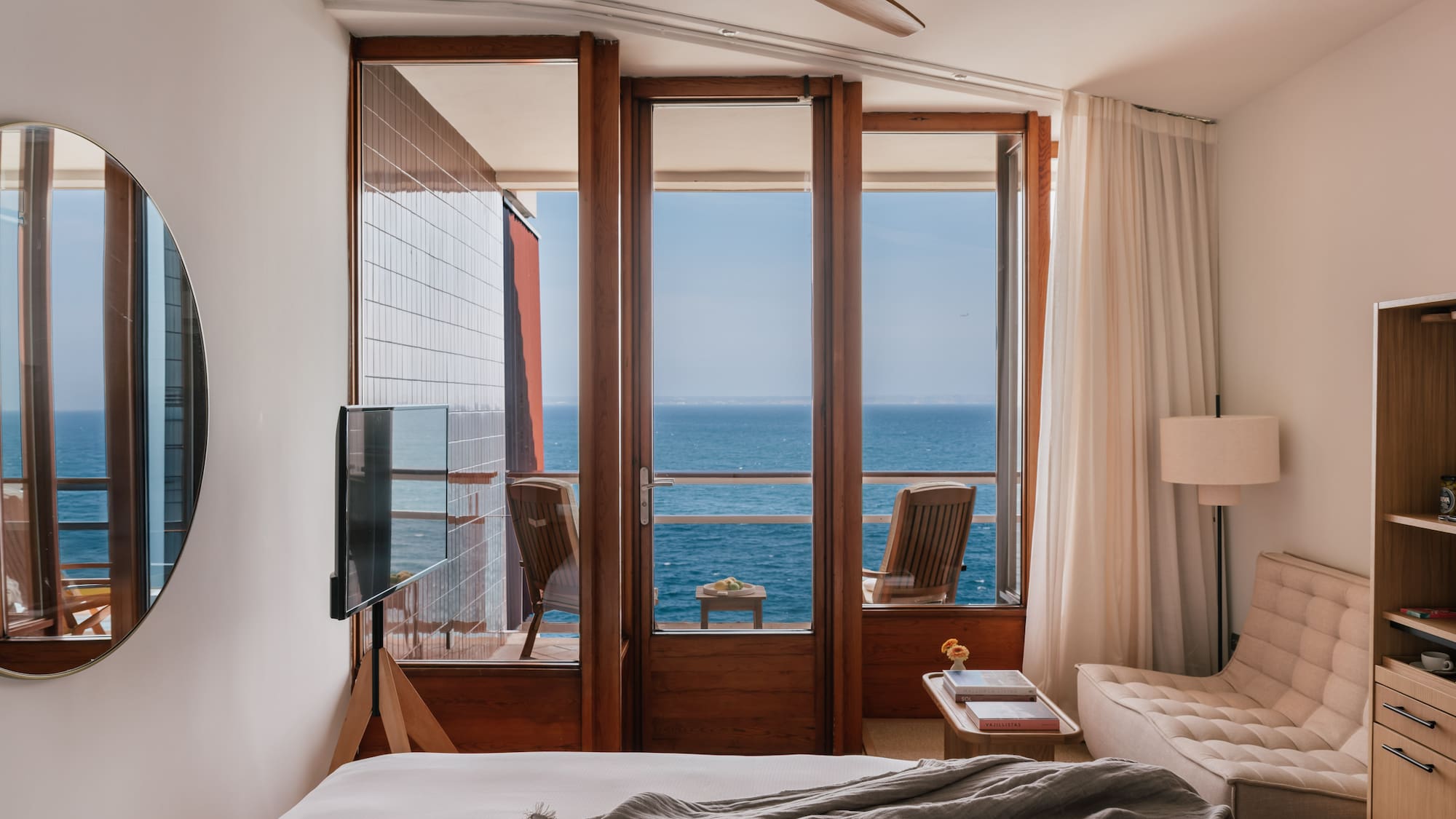 a bedroom with a view of the ocean from the balcony