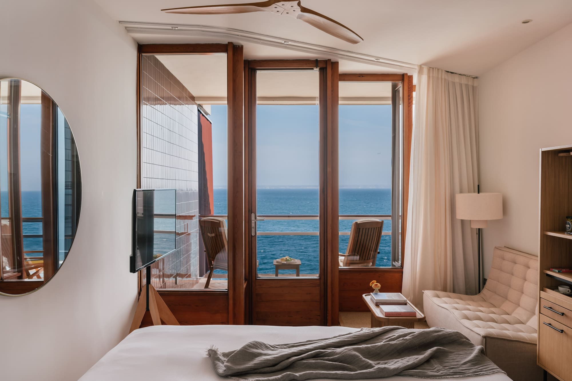 a bedroom with a view of the ocean from the balcony