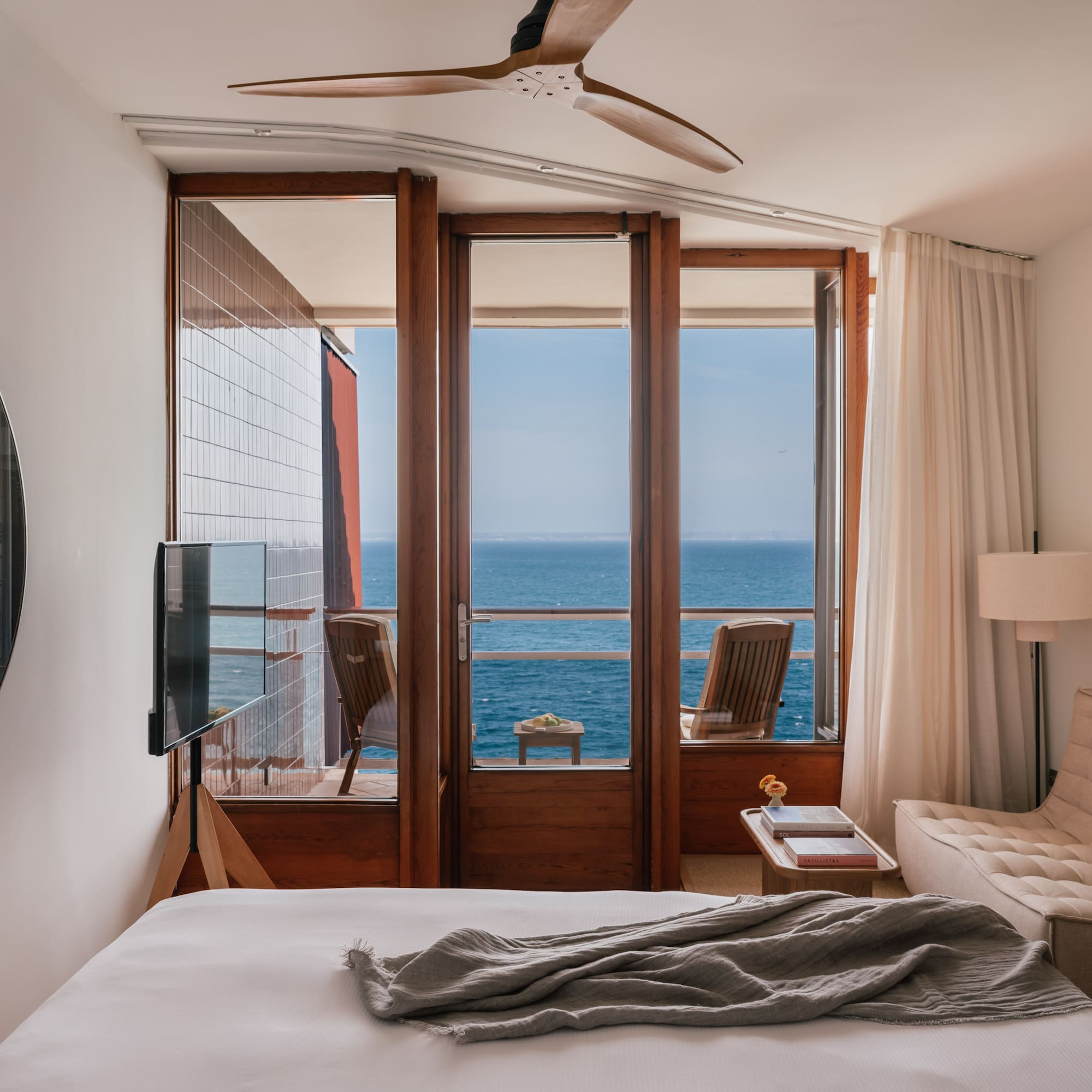 a bedroom with a view of the ocean from the balcony