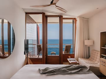 a bedroom with a view of the ocean from the balcony