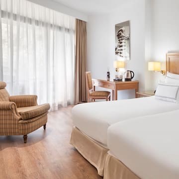 a room with two beds and a chair