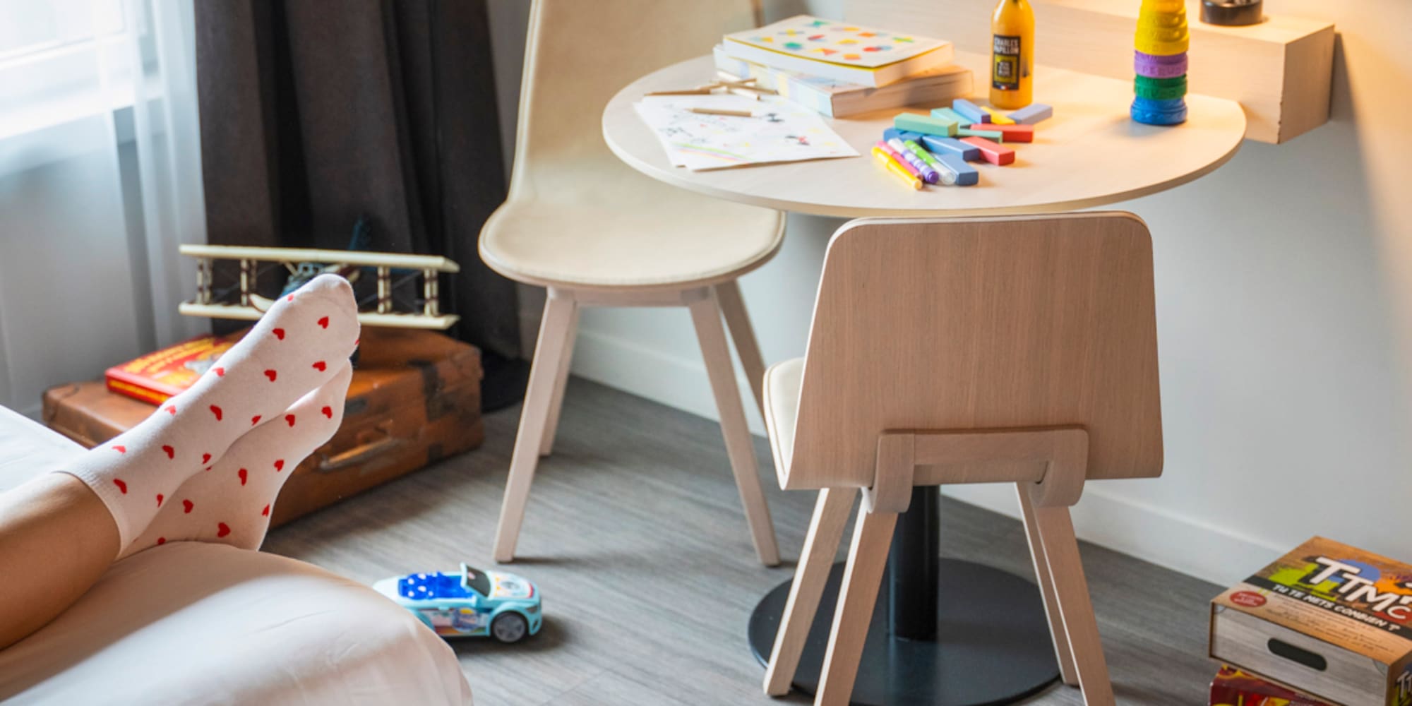 a room with a table and chairs and a table with toys