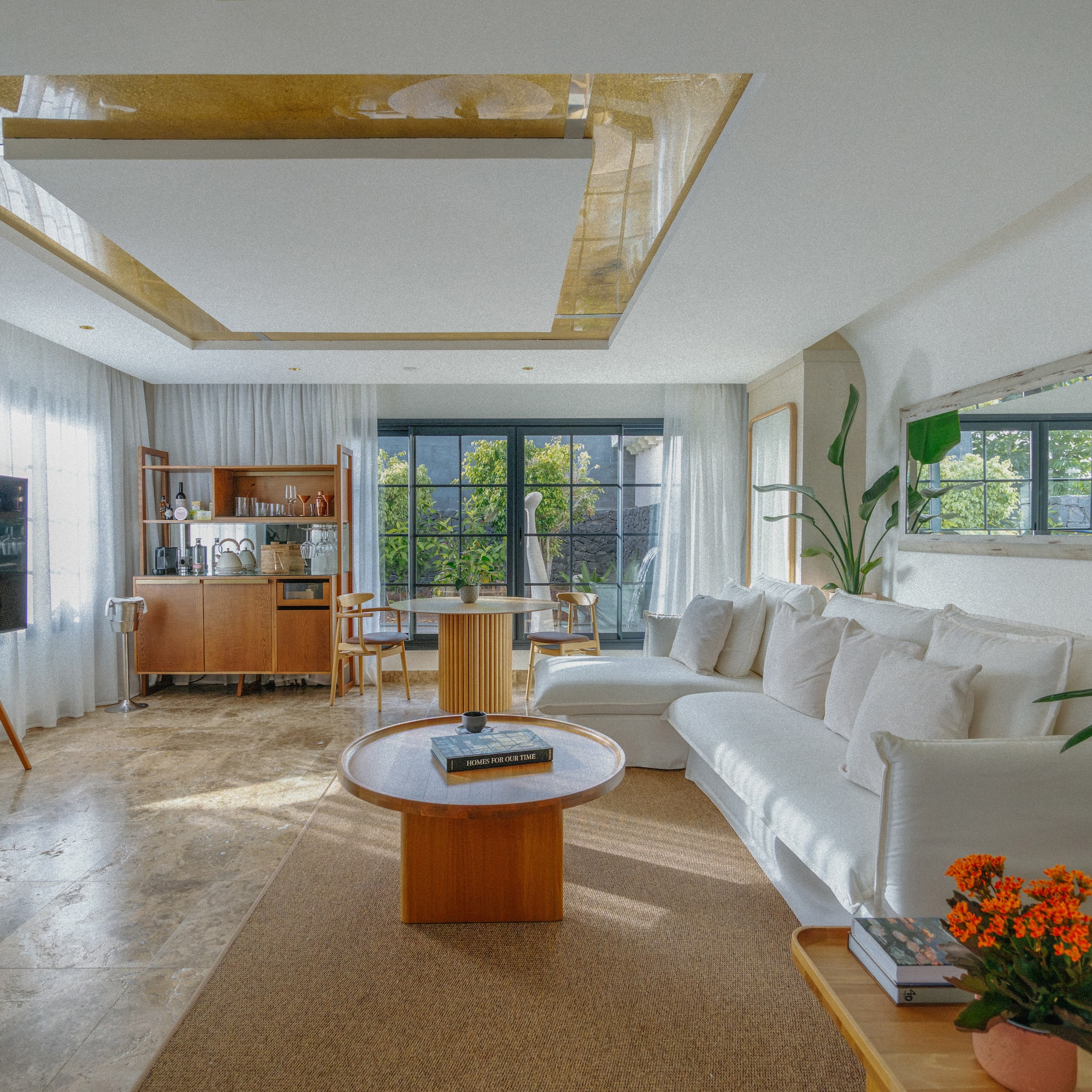 Bright modern living room with white sofa, wood furniture, and garden view.