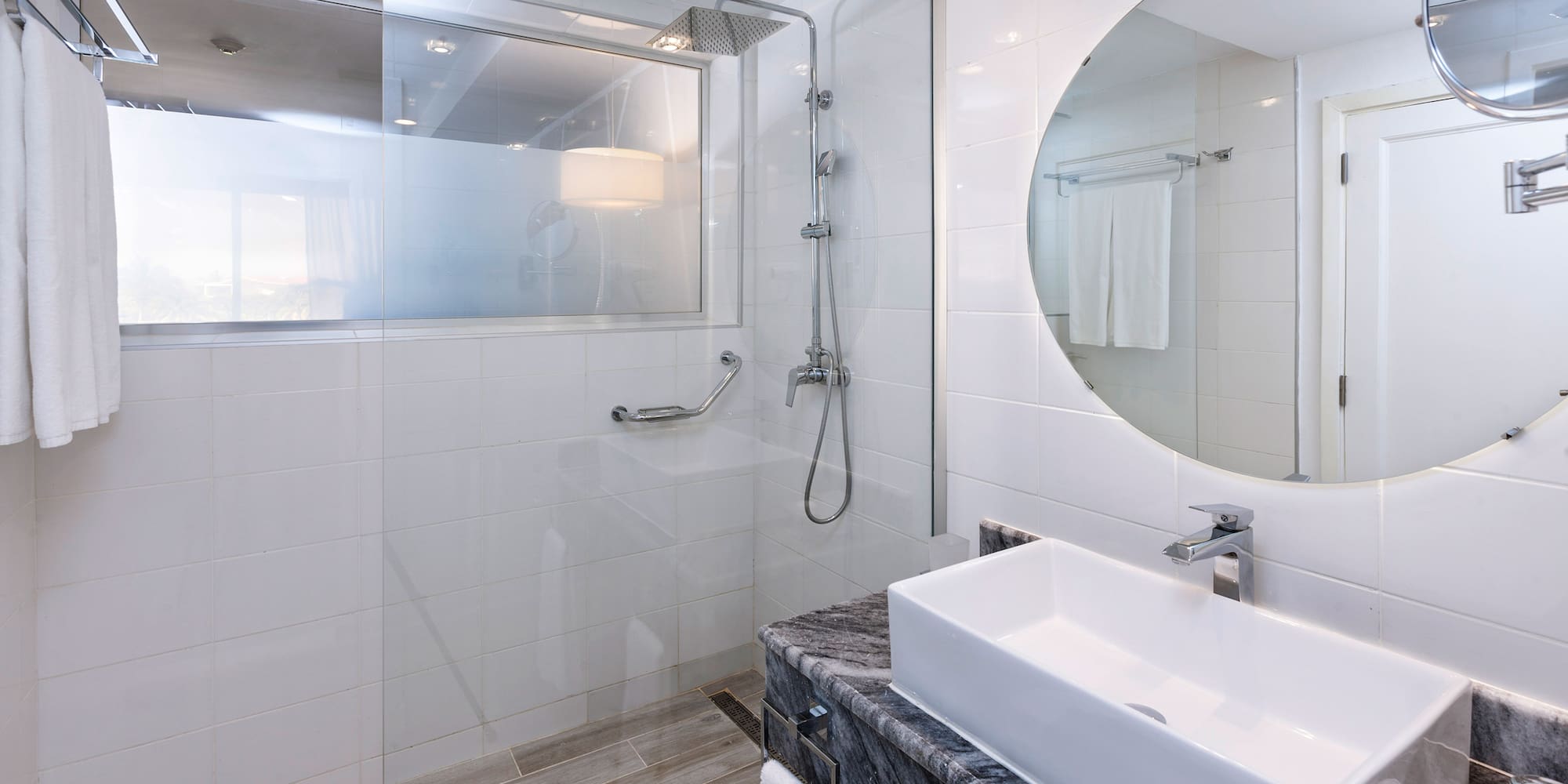 a bathroom with a round mirror and a sink