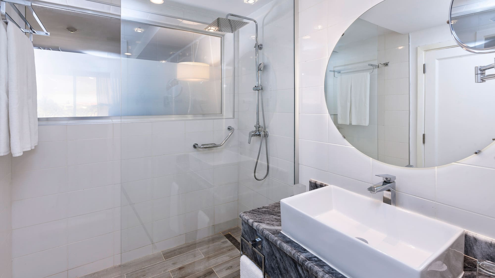 a bathroom with a round mirror and a sink