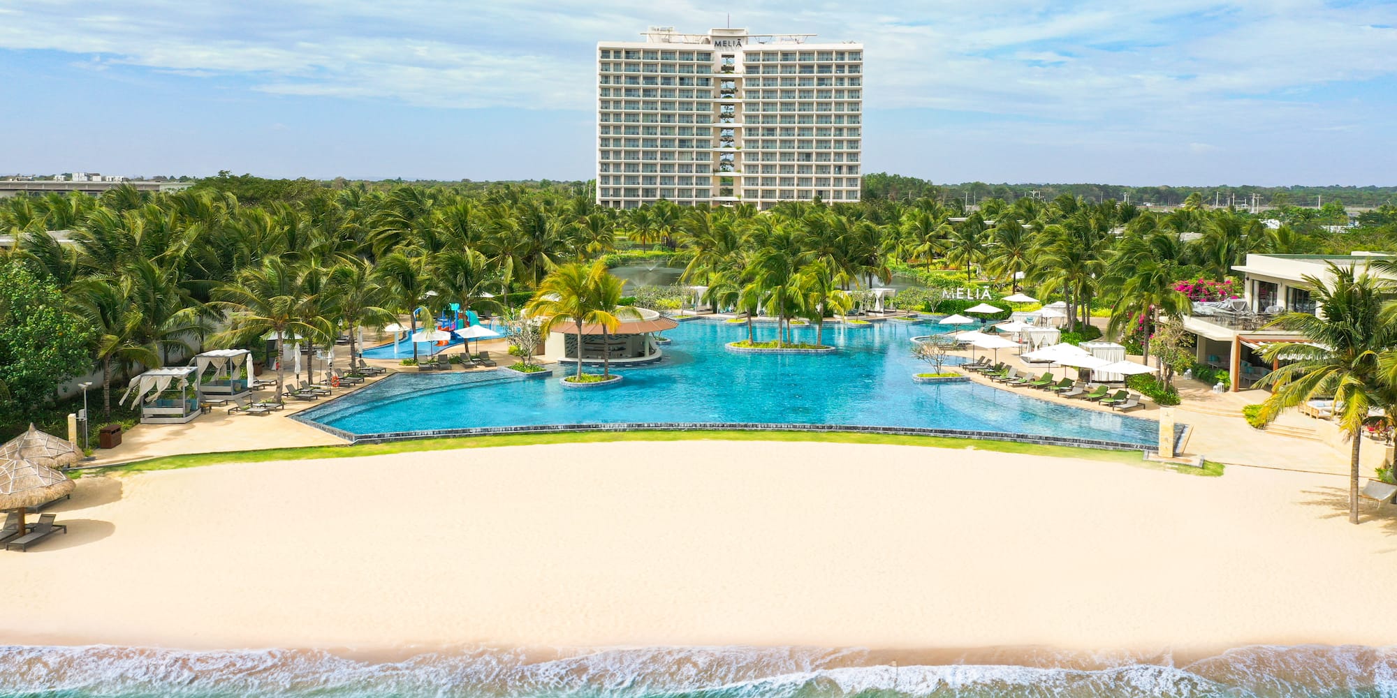 a pool with palm trees and a building in the background