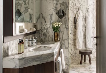 a bathroom with marble countertop and white towels