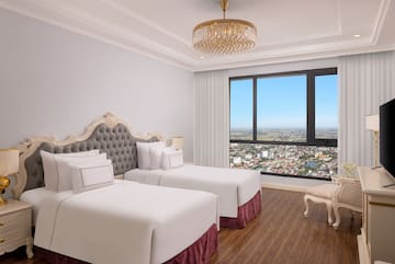 a room with two beds and a large window