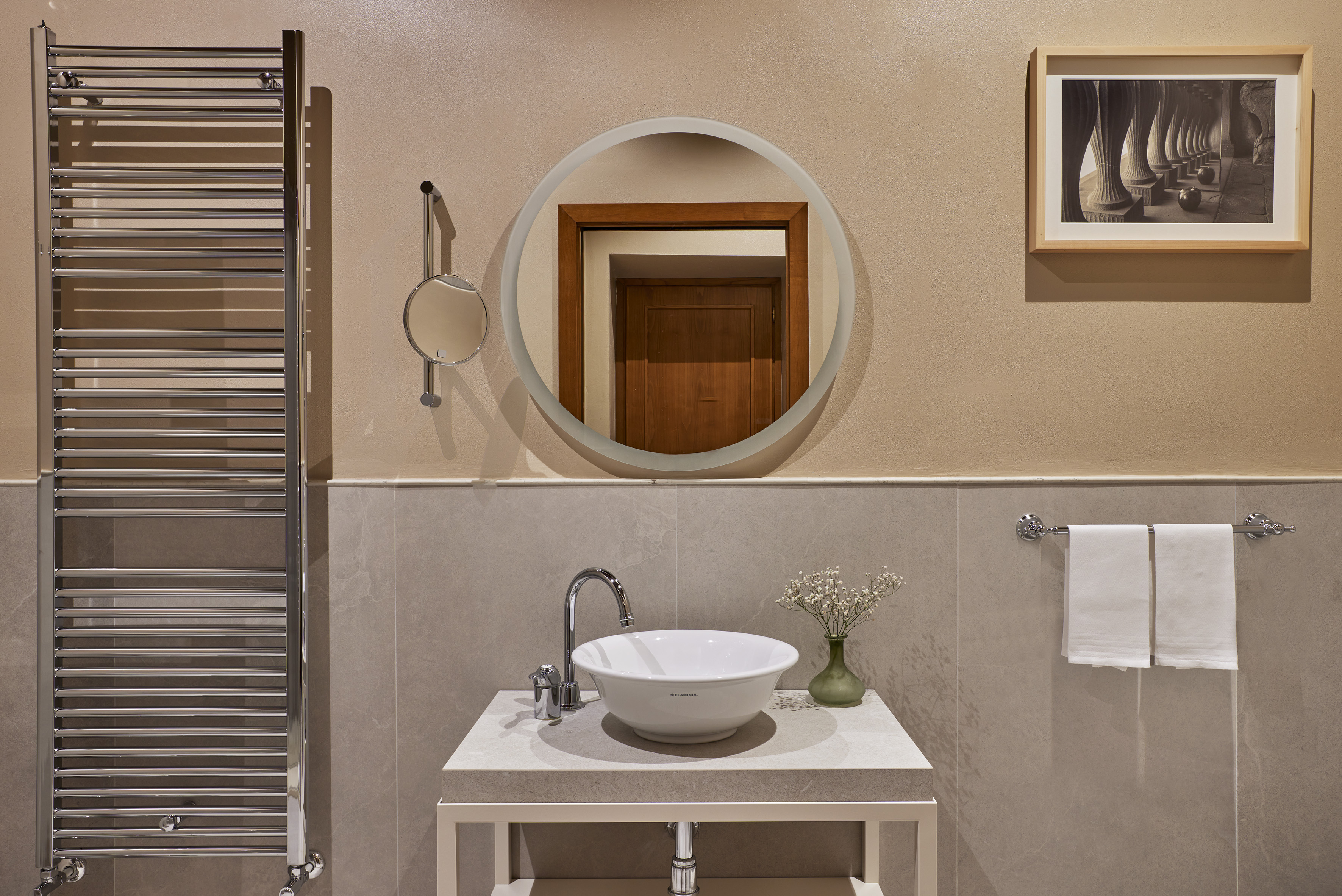 a bathroom with a round mirror and a sink