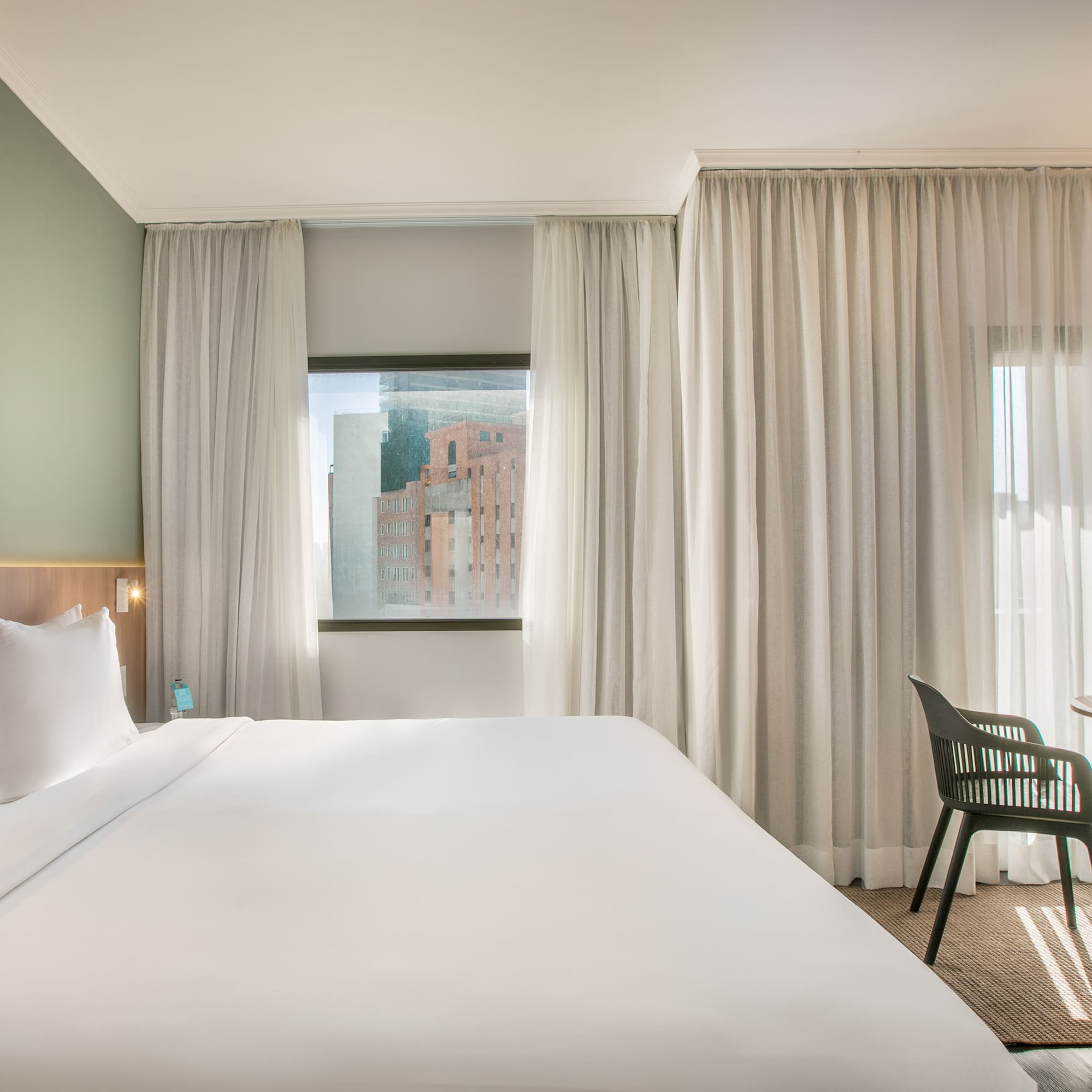 a bed in a room with white curtains