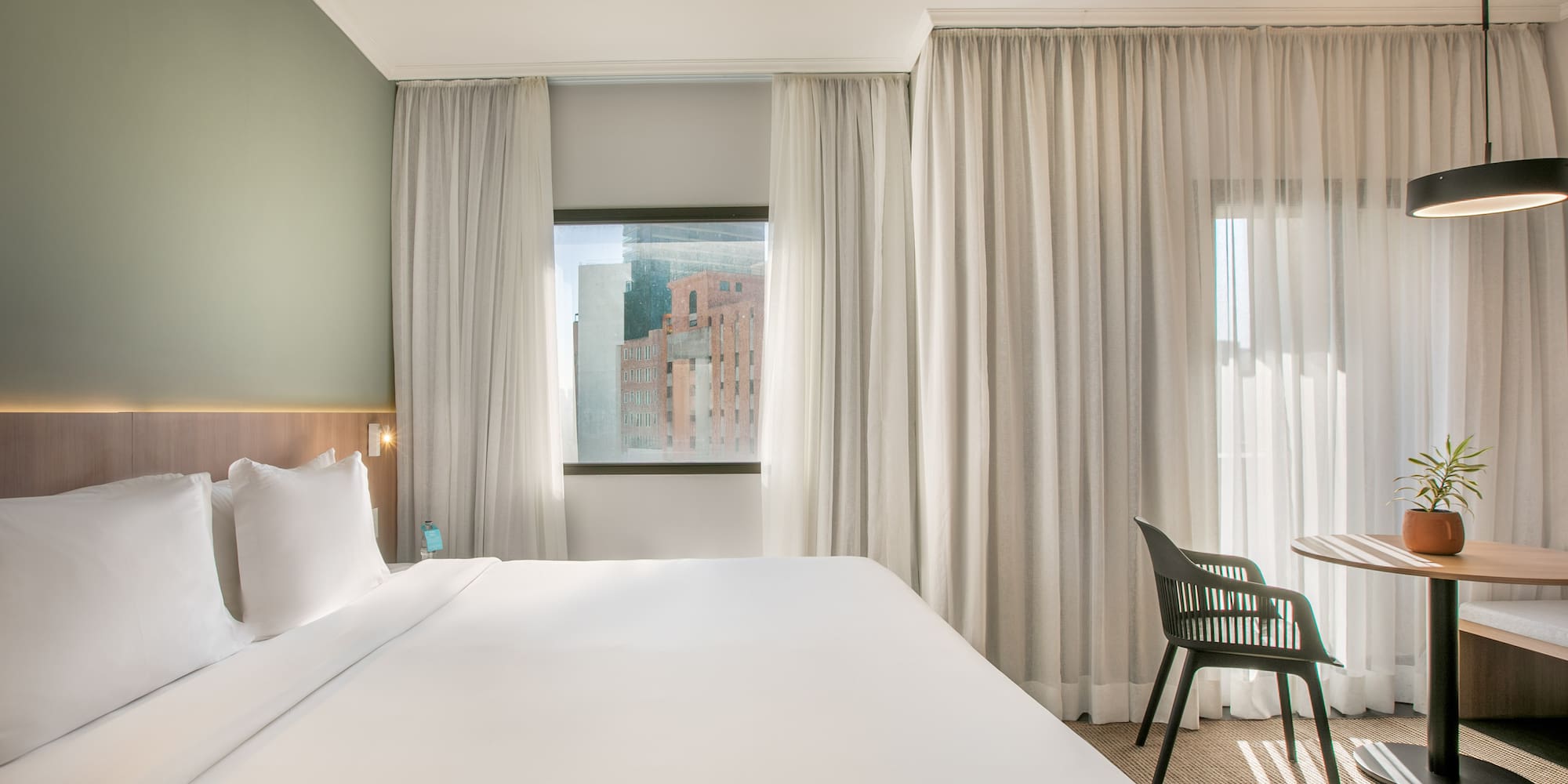 a bed in a room with white curtains