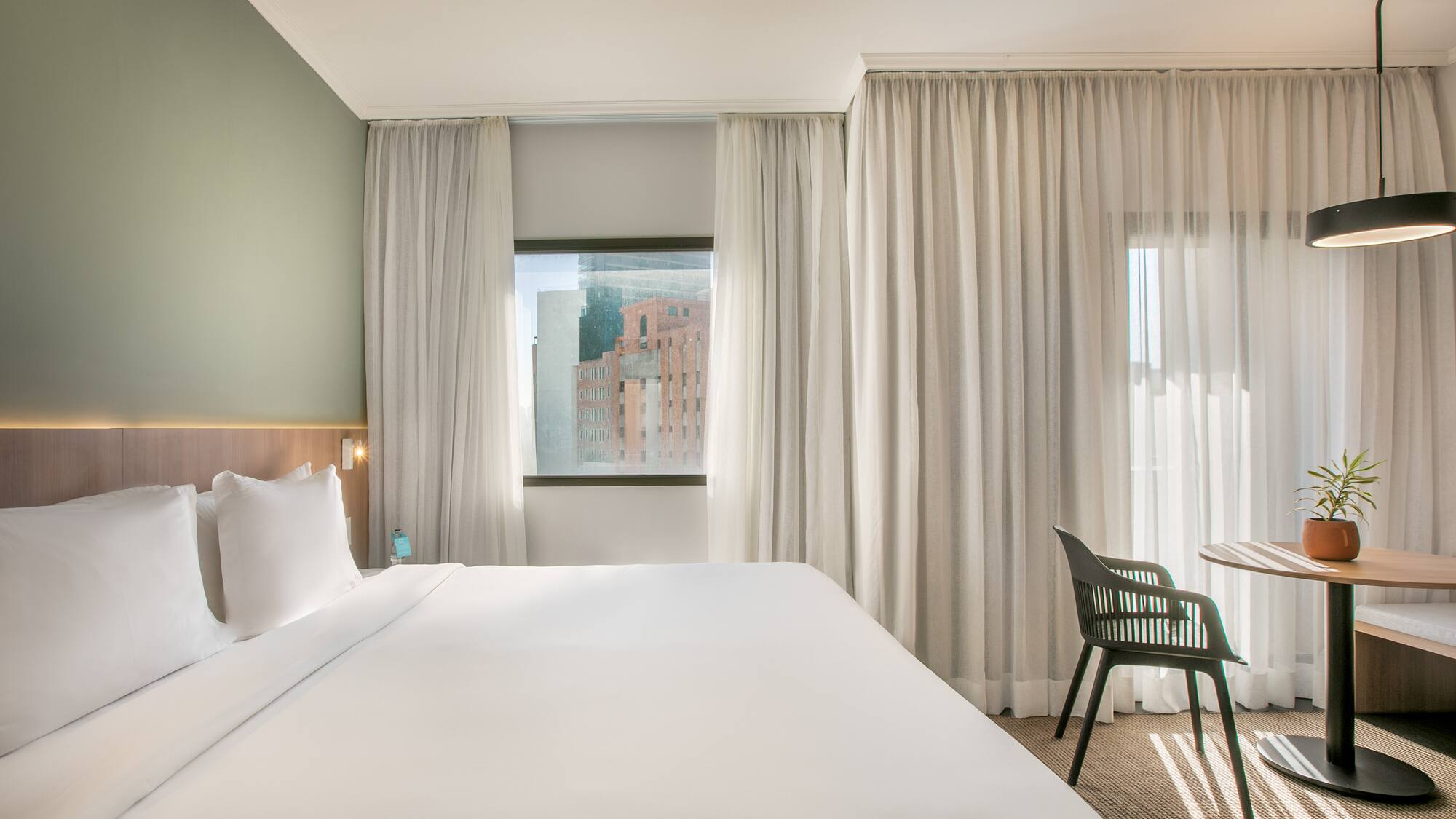 a bed in a room with white curtains