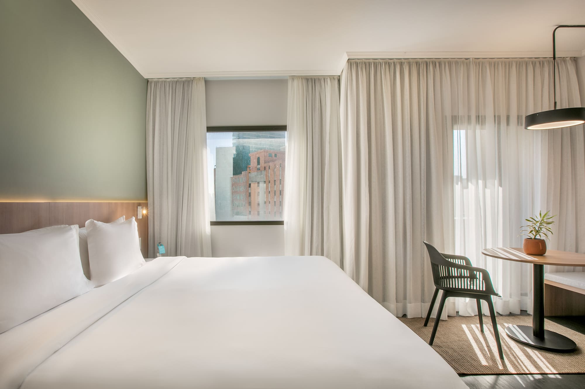 a bed in a room with white curtains