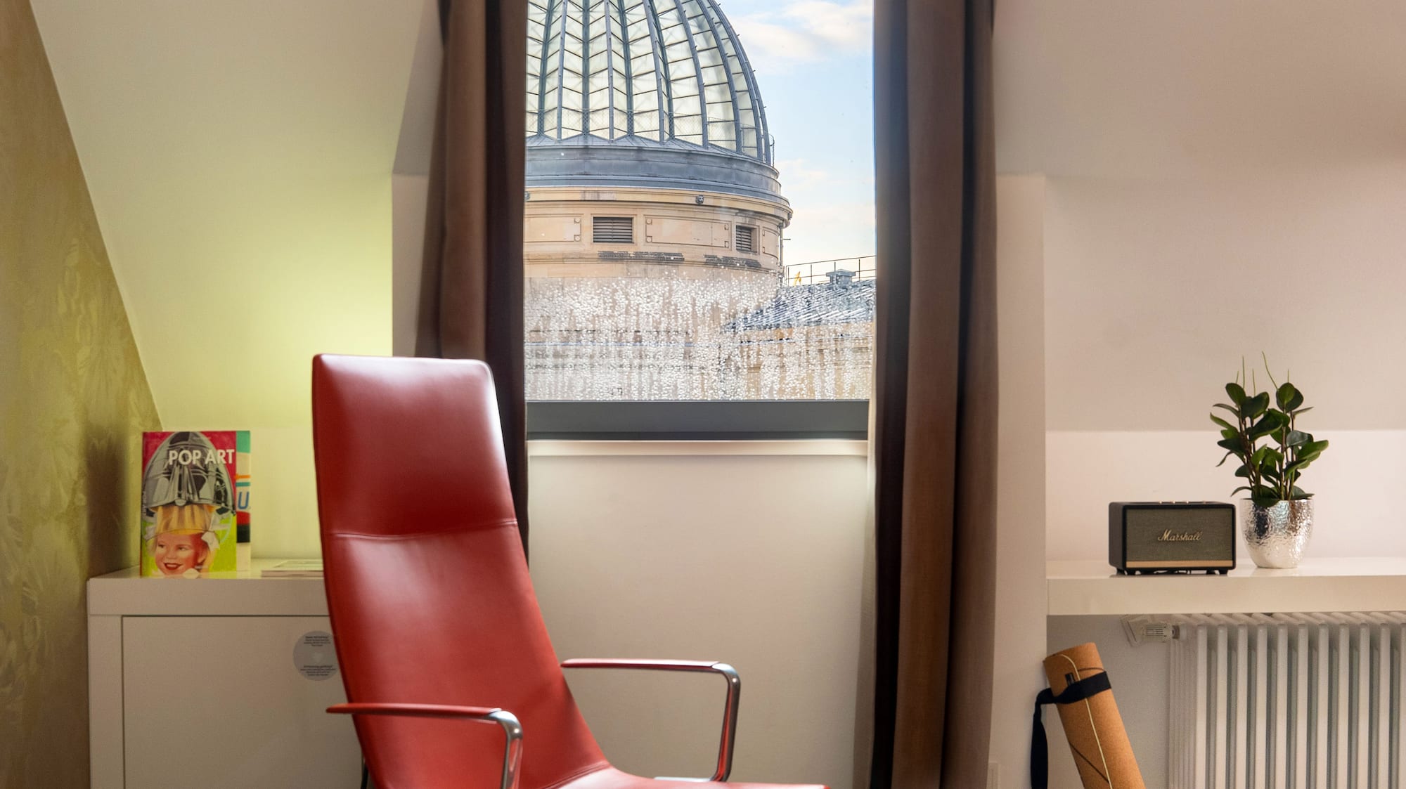 a red chair in a room with a window