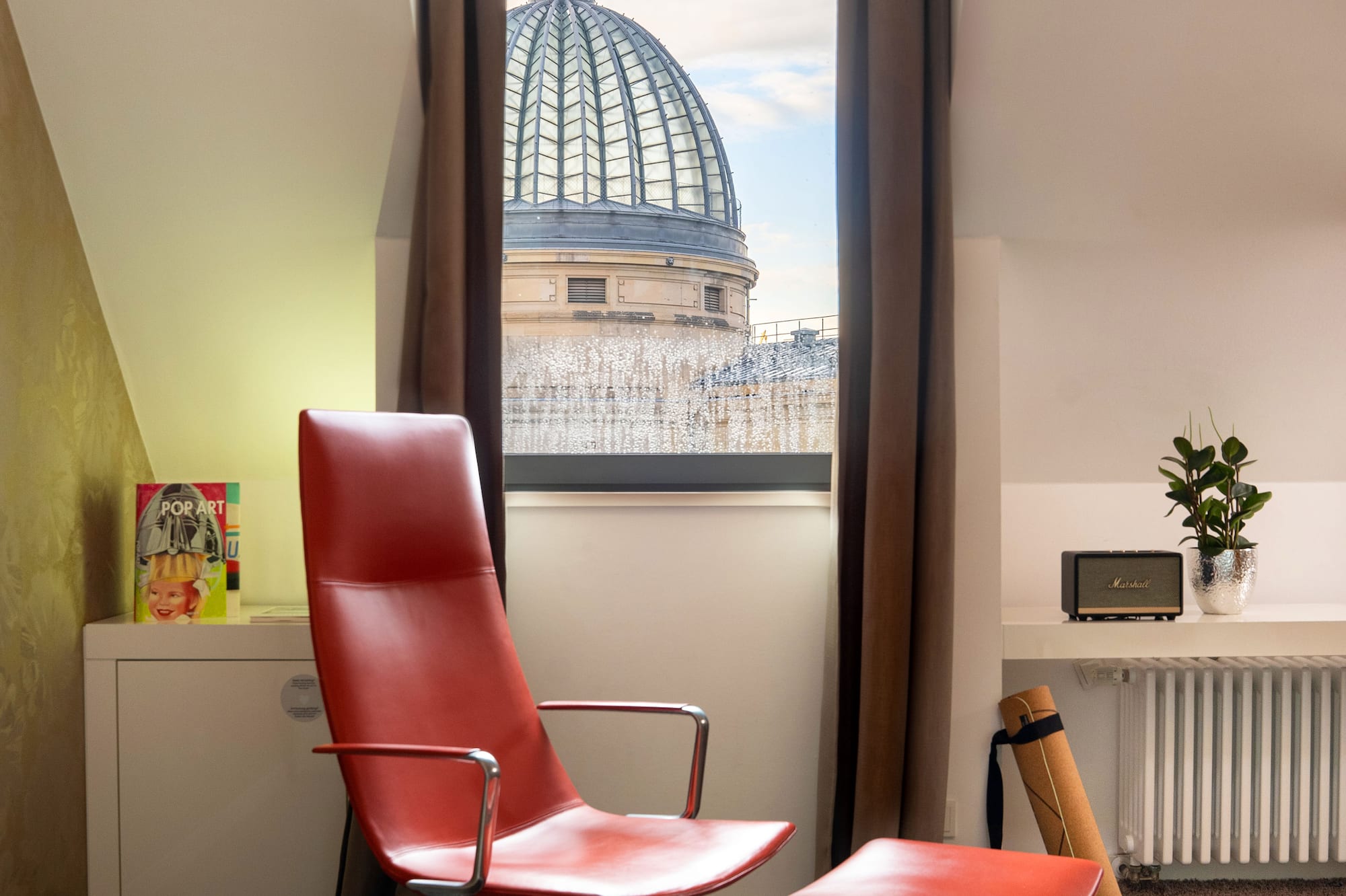 a red chair in a room with a window