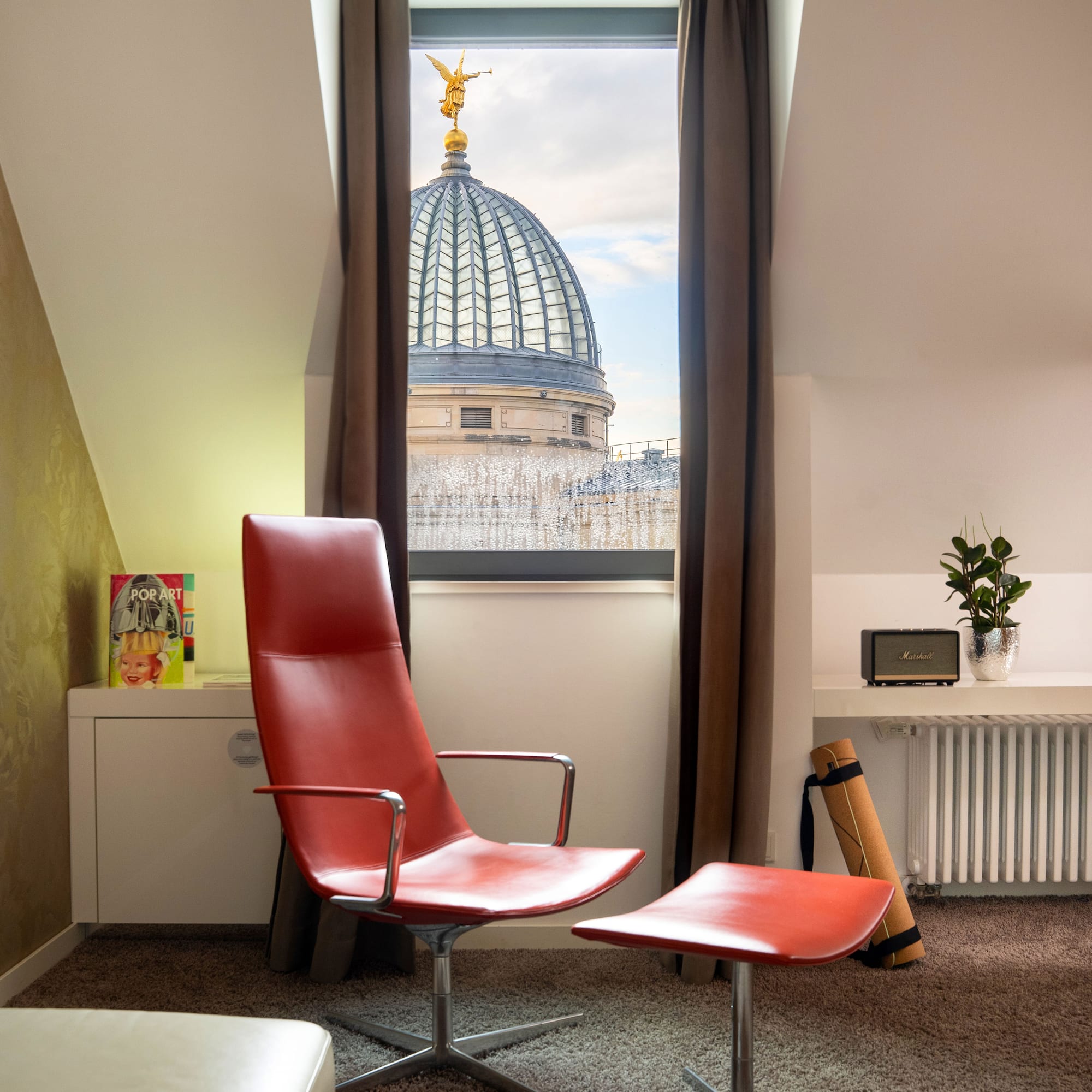 a red chair in a room with a window