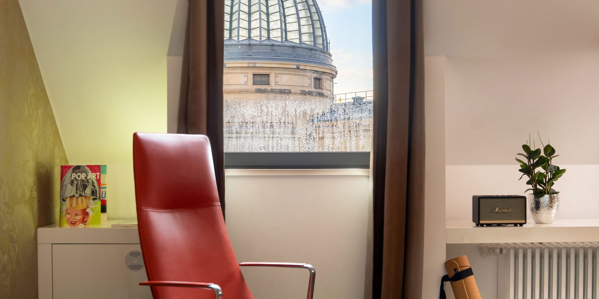 a red chair in a room with a window