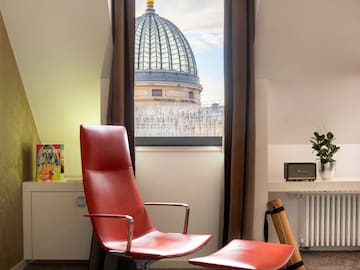 a red chair in a room with a window