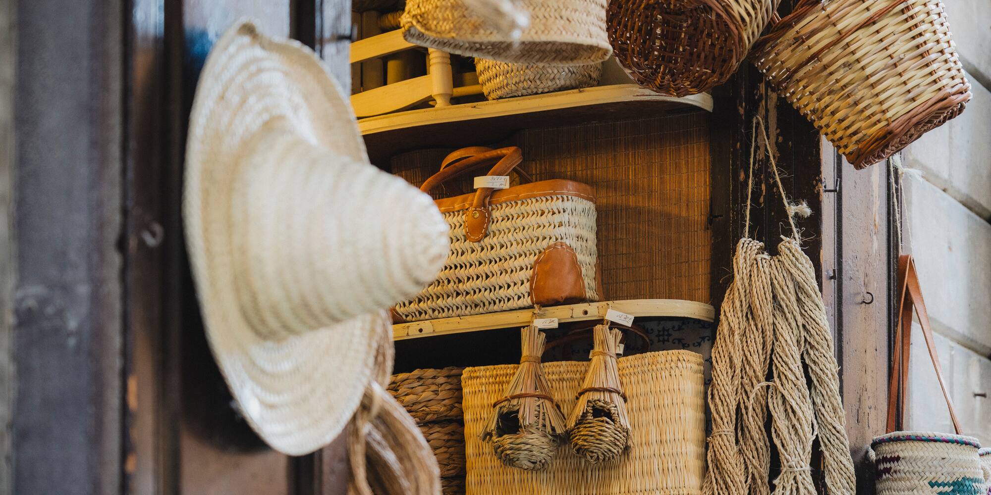 a shelf with baskets and straw hat