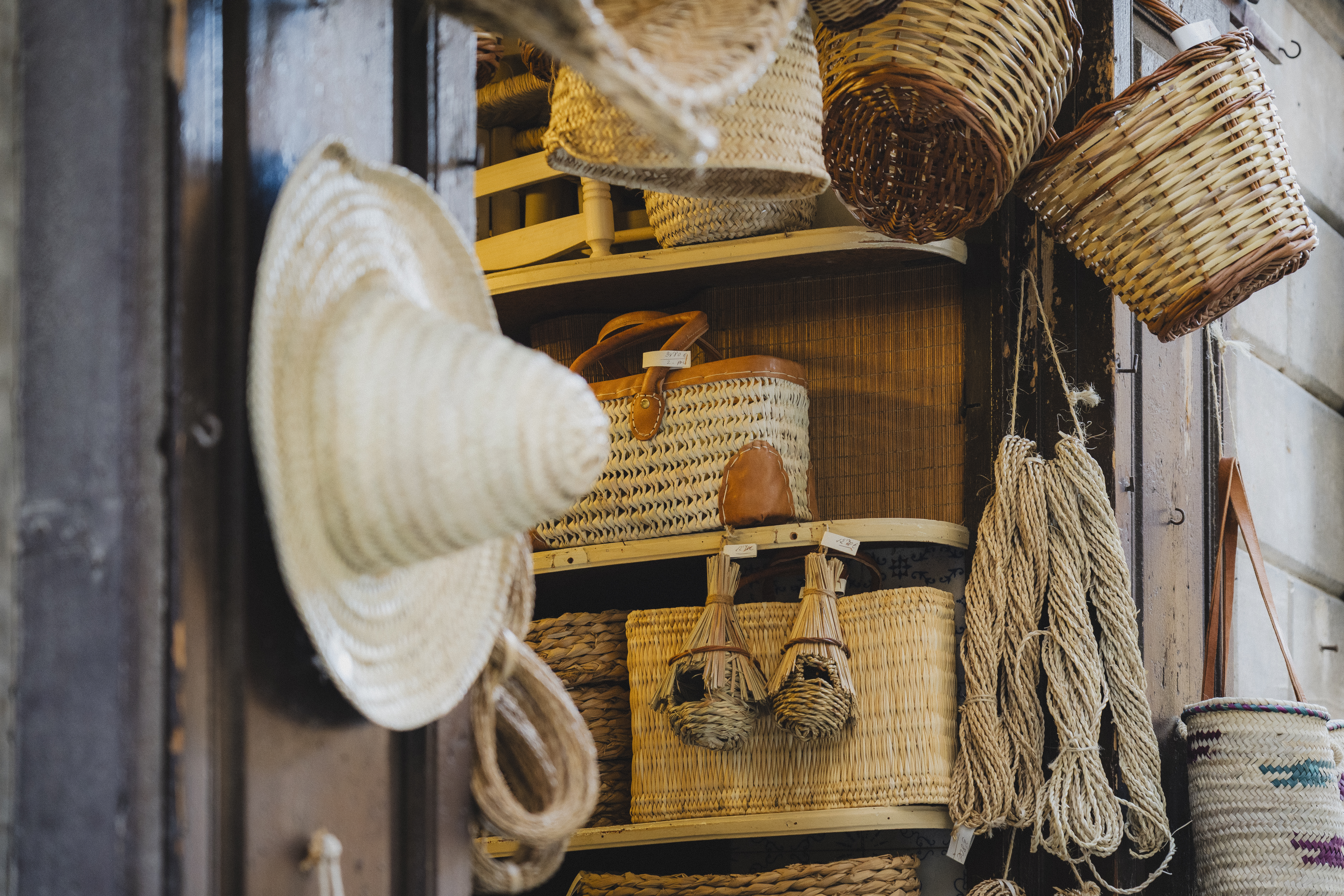 a shelf with baskets and straw hat