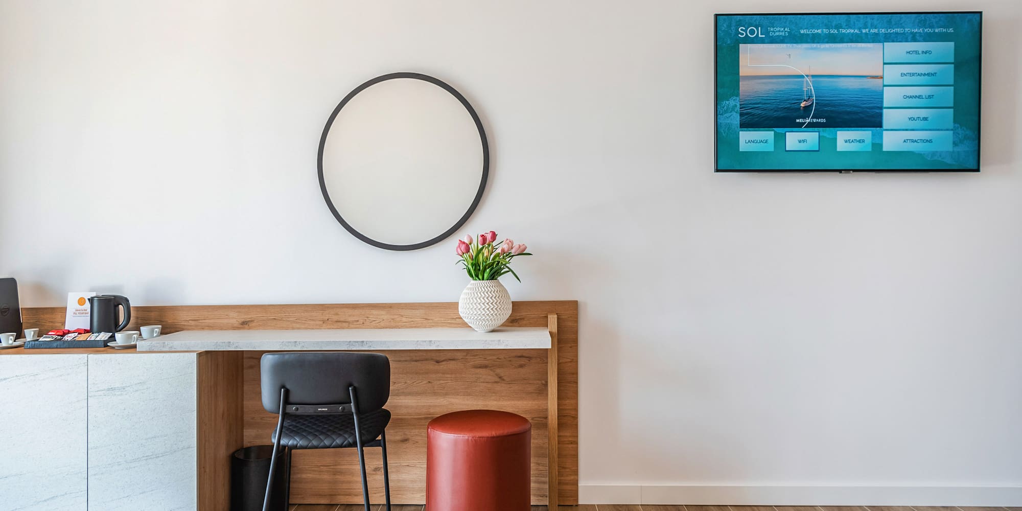 a room with a table and chair and a television on the wall