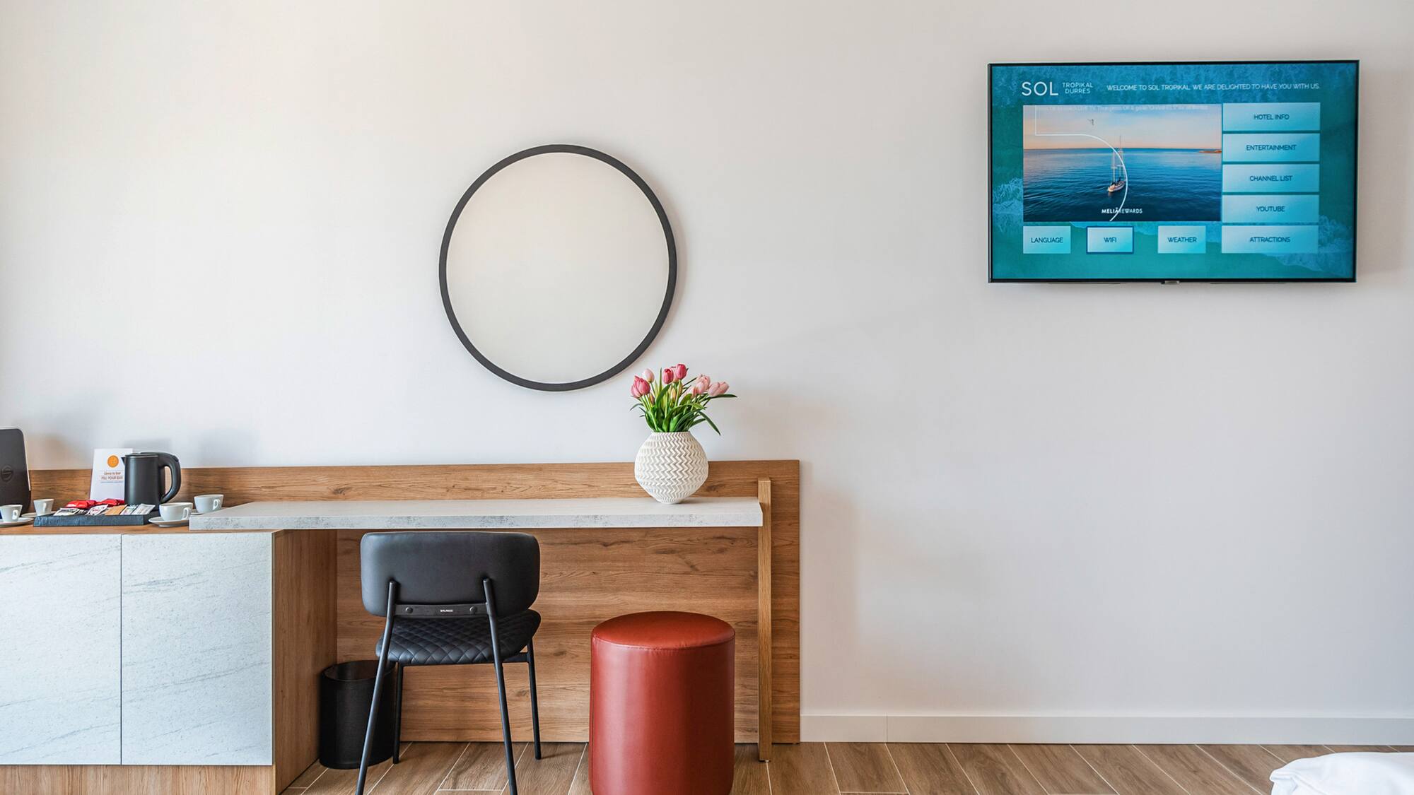 a room with a table and chair and a television on the wall
