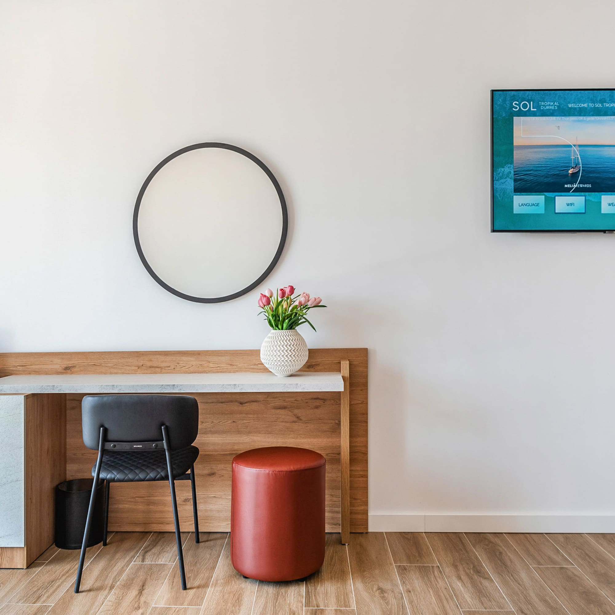 a room with a table and chair and a television on the wall