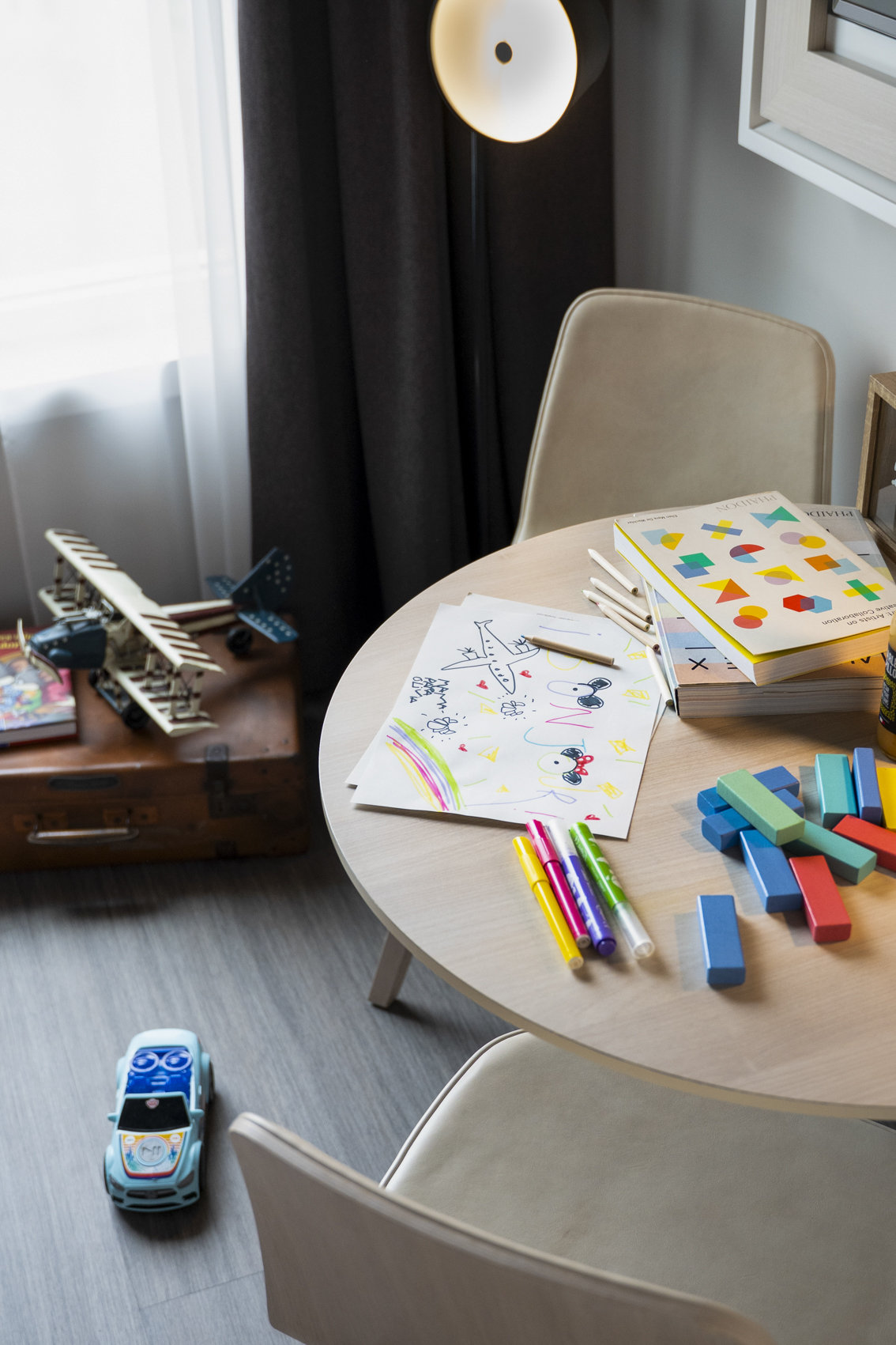 Creative kids' play area with drawings, markers, colorful blocks, and toys.