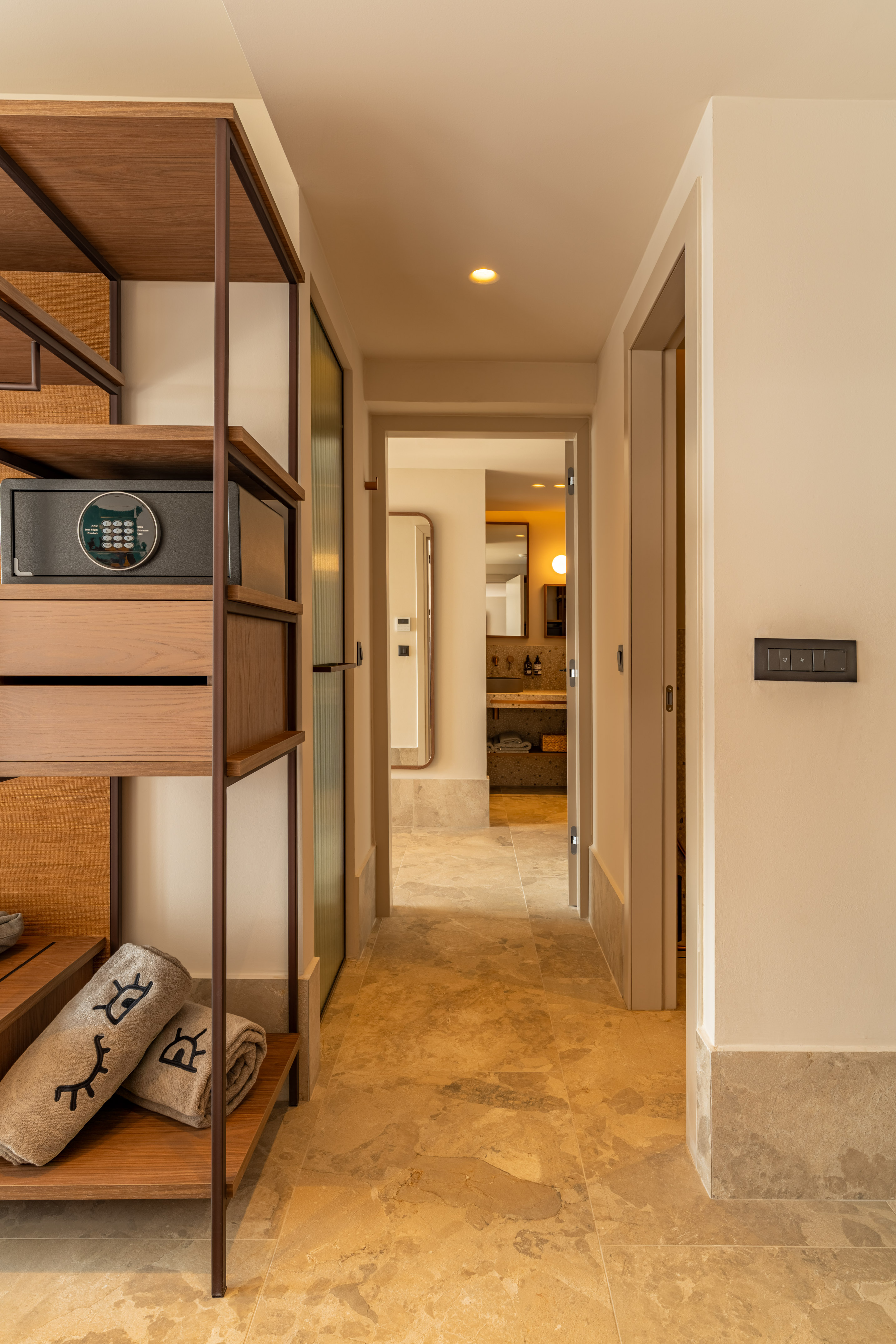 Modern hotel hallway with wardrobe, in-room safe, and bathroom entrance.