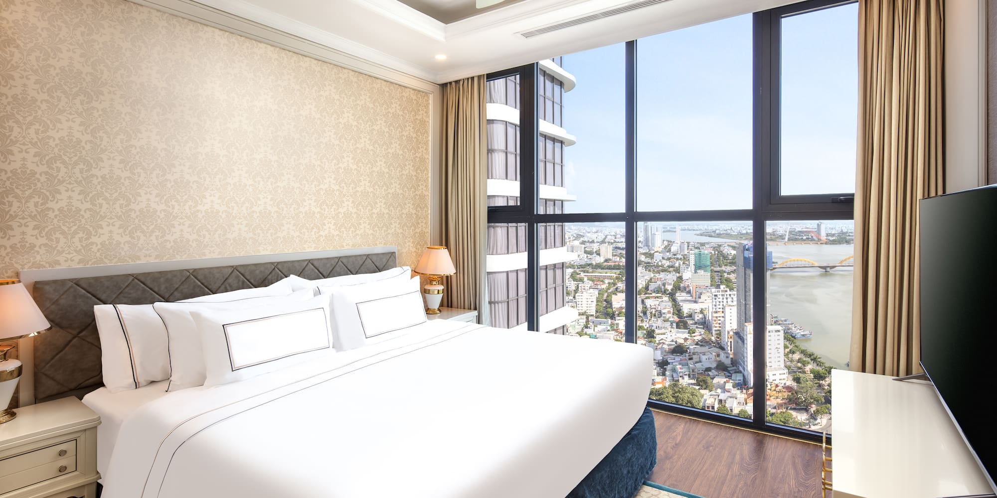 a bedroom with a large window overlooking a city