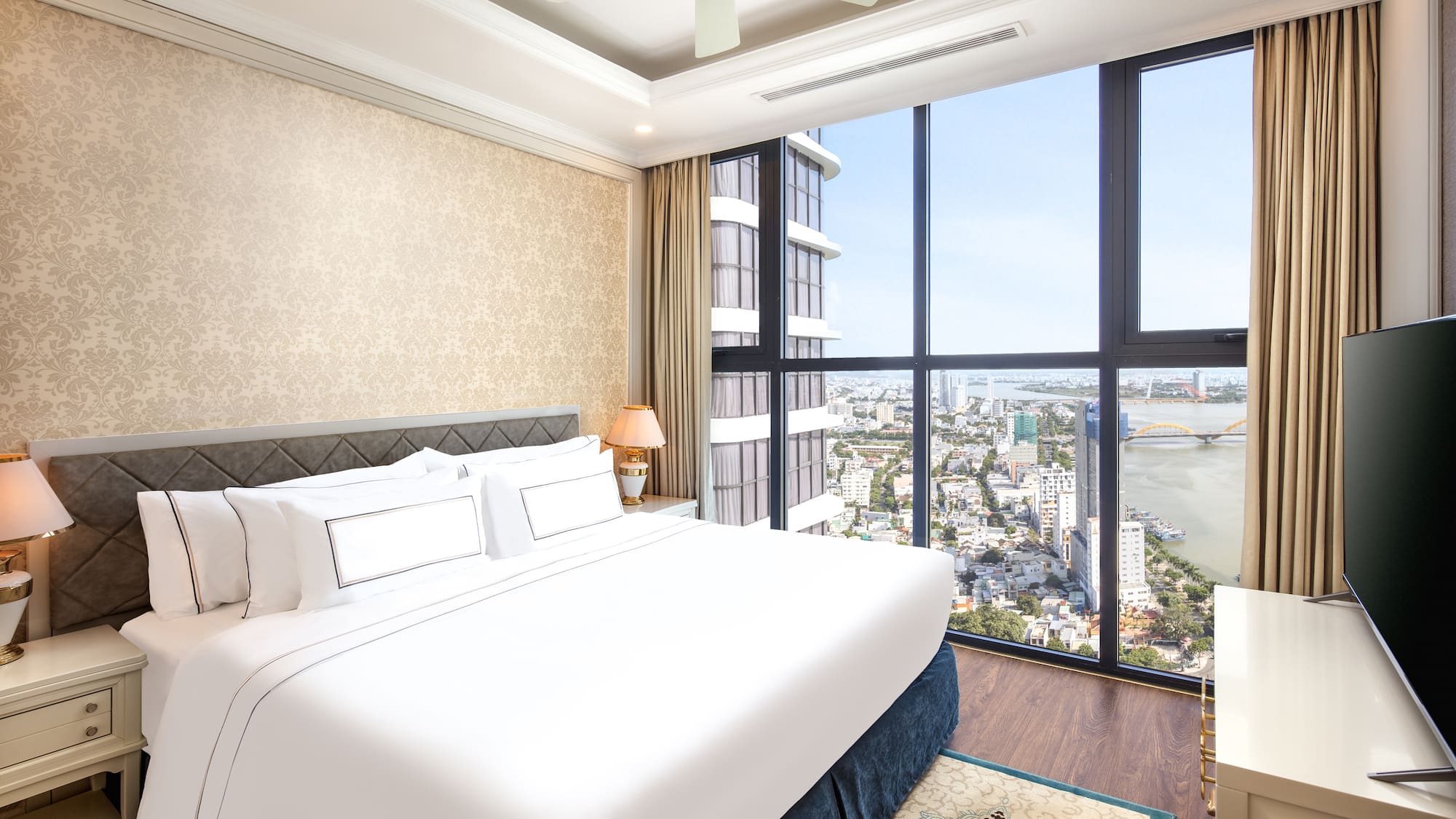 a bedroom with a large window overlooking a city