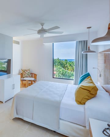 a bedroom with a large window and a bed