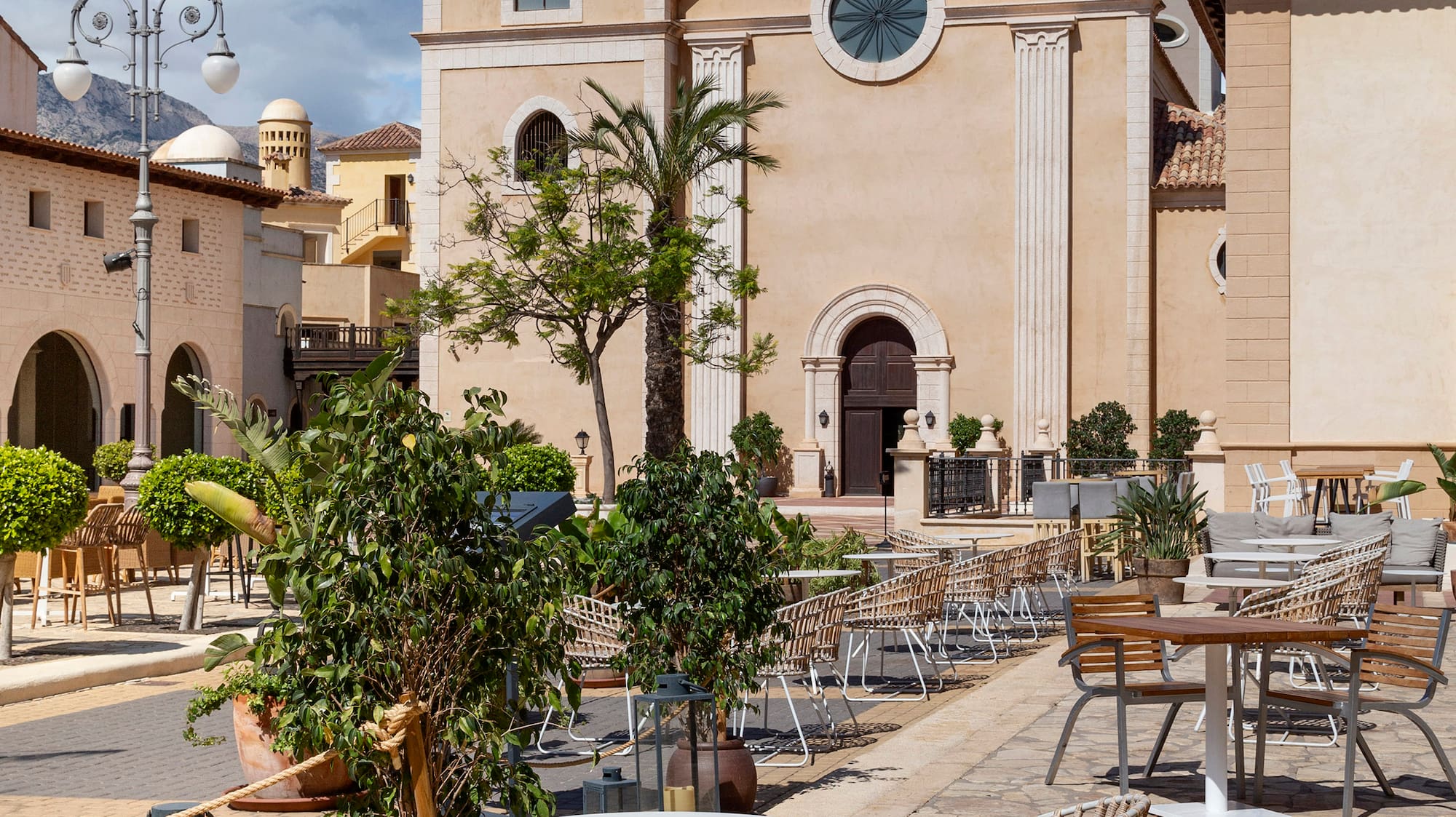 a building with a clock tower and tables and chairs