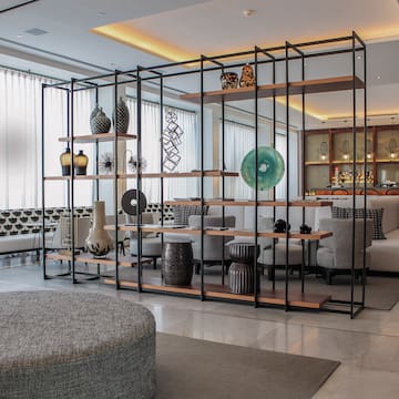 a room with a large metal structure with shelves and chairs