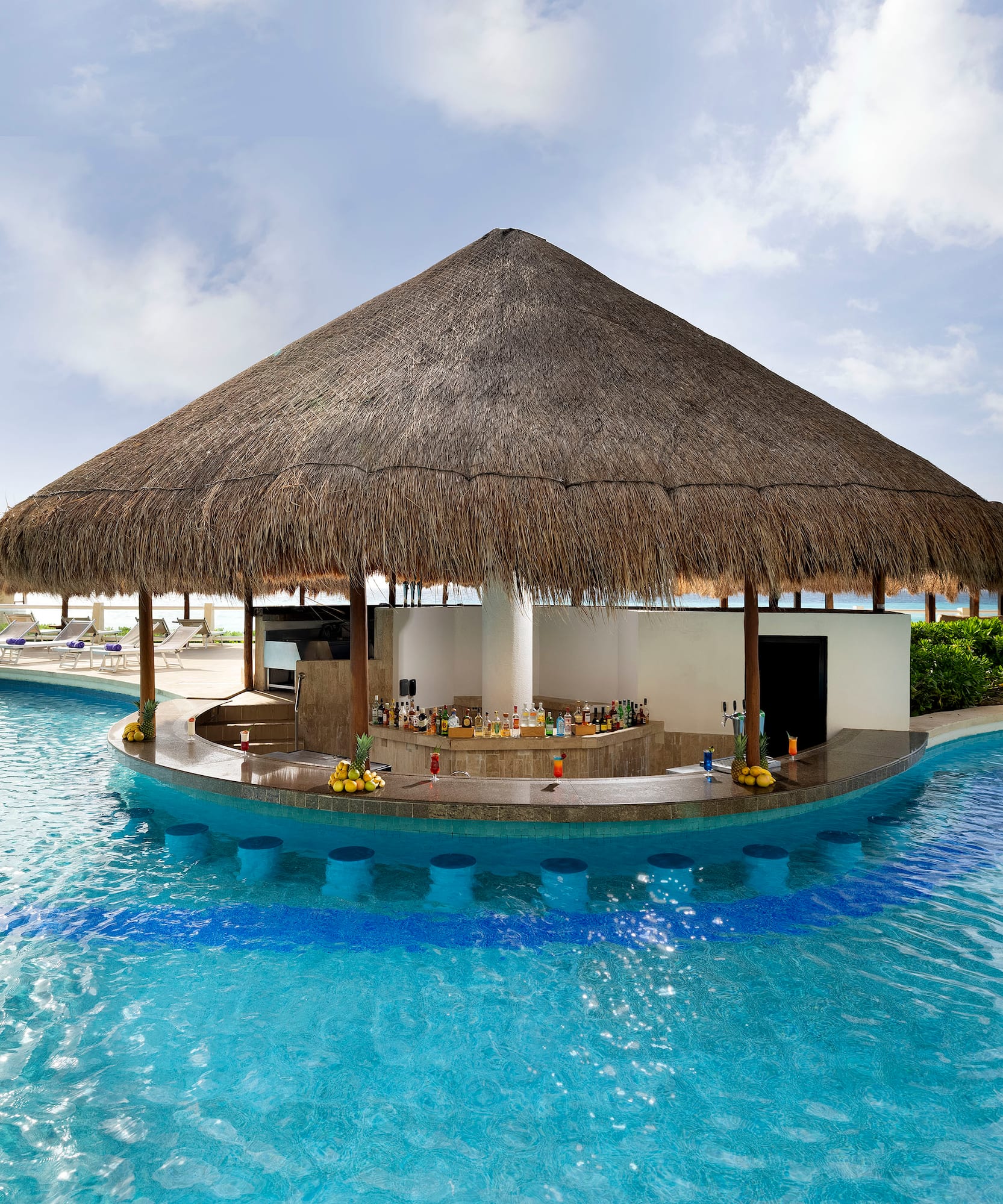a pool with a bar and a straw roof