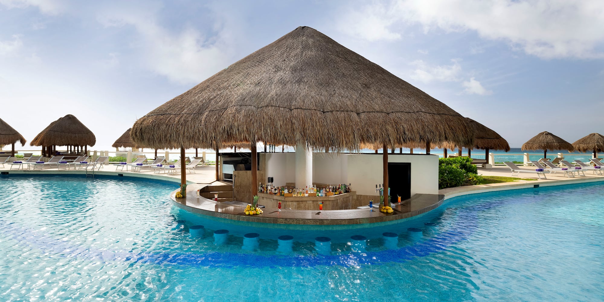 a pool with a bar and a straw roof