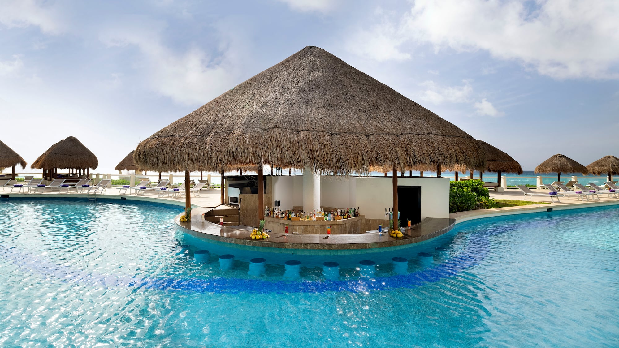 a pool with a bar and a straw roof