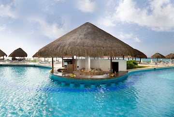 a pool with a bar and a straw roof