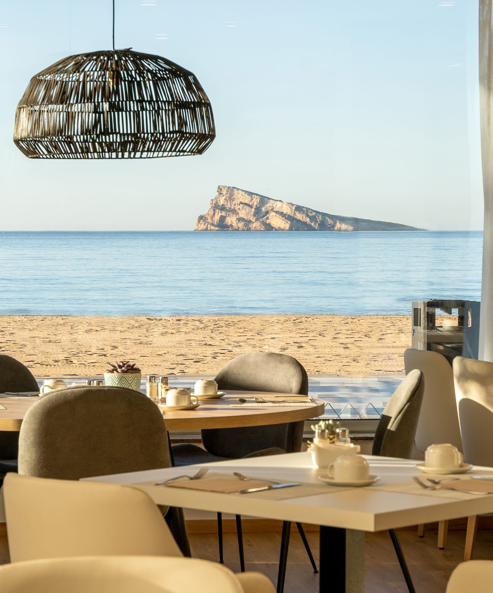 a room with tables and chairs on a beach