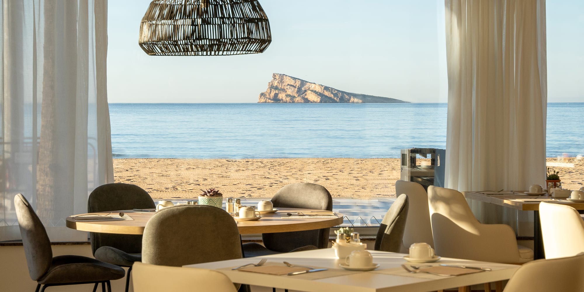 a room with tables and chairs on a beach