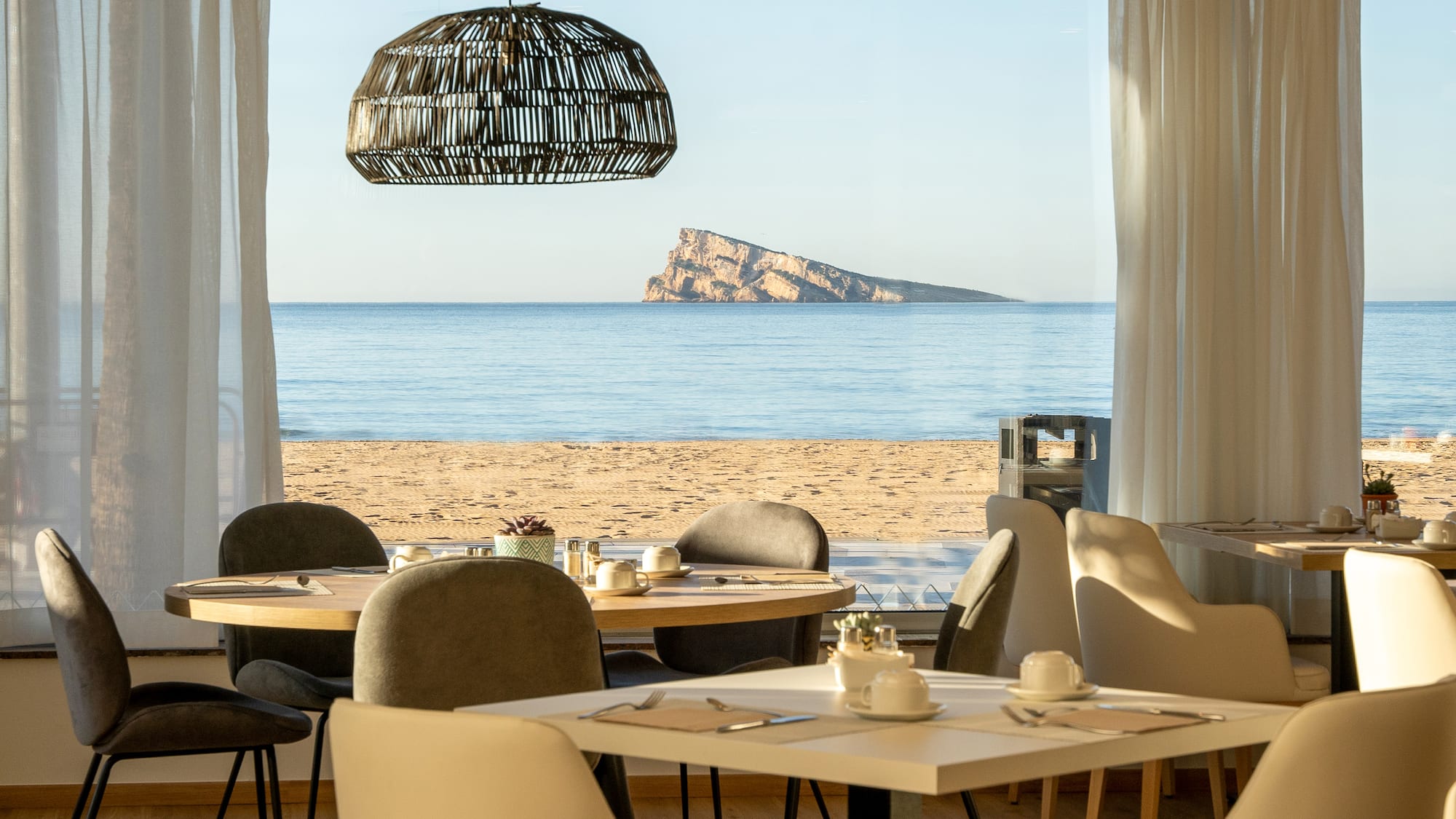 a room with tables and chairs on a beach